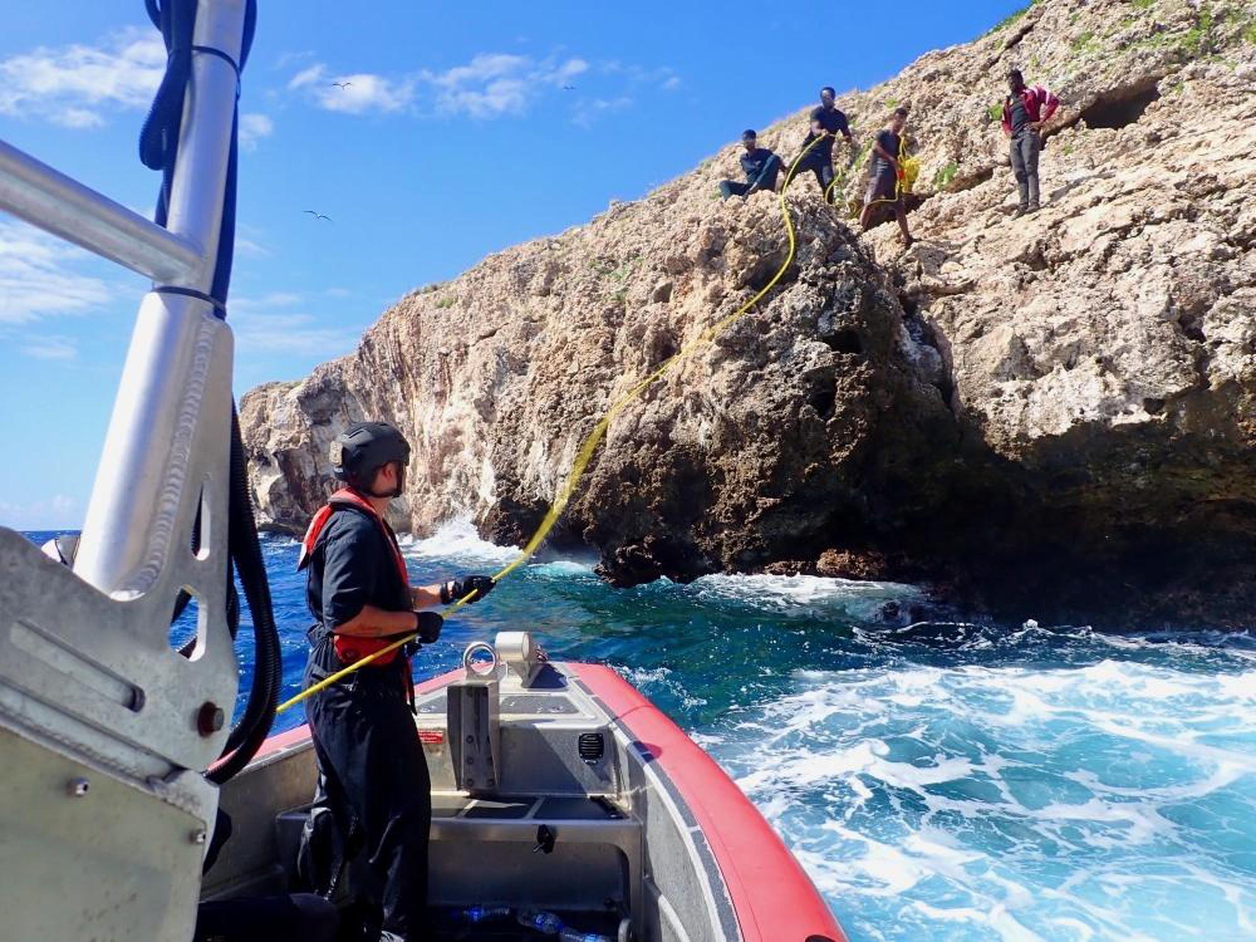 La tripulación del barco Joseph Tezanos de la Guardia Costanera durante el rescate 12 haitianos que fueron abandonados por contrabandistas en un acantilado rocoso del cayo Monito, en Puerto Rico.