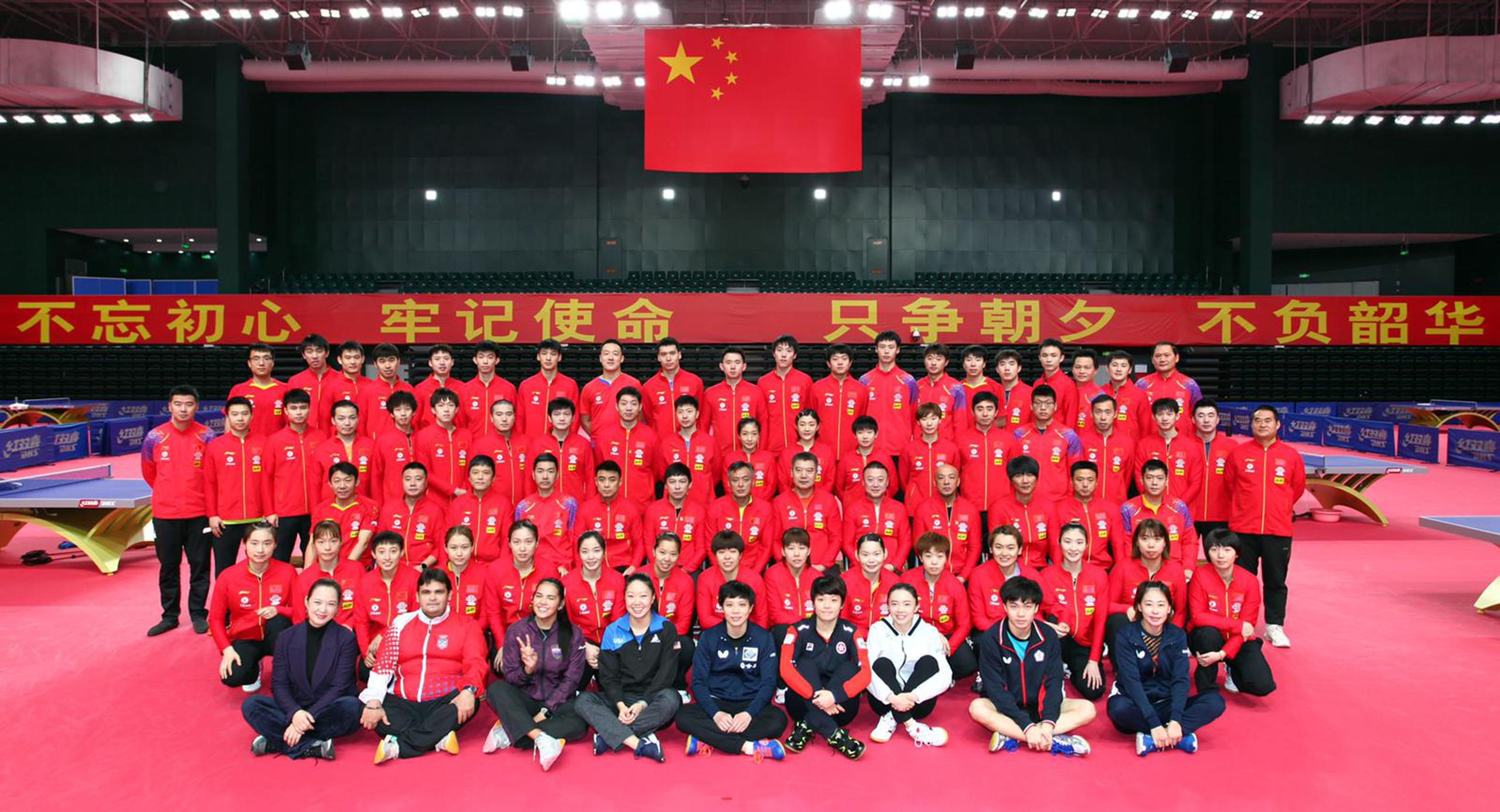 Adriana Díaz (tercera de izquierda a derecha en la primera fila) posa con el grupo de atletas acuartelados en China.