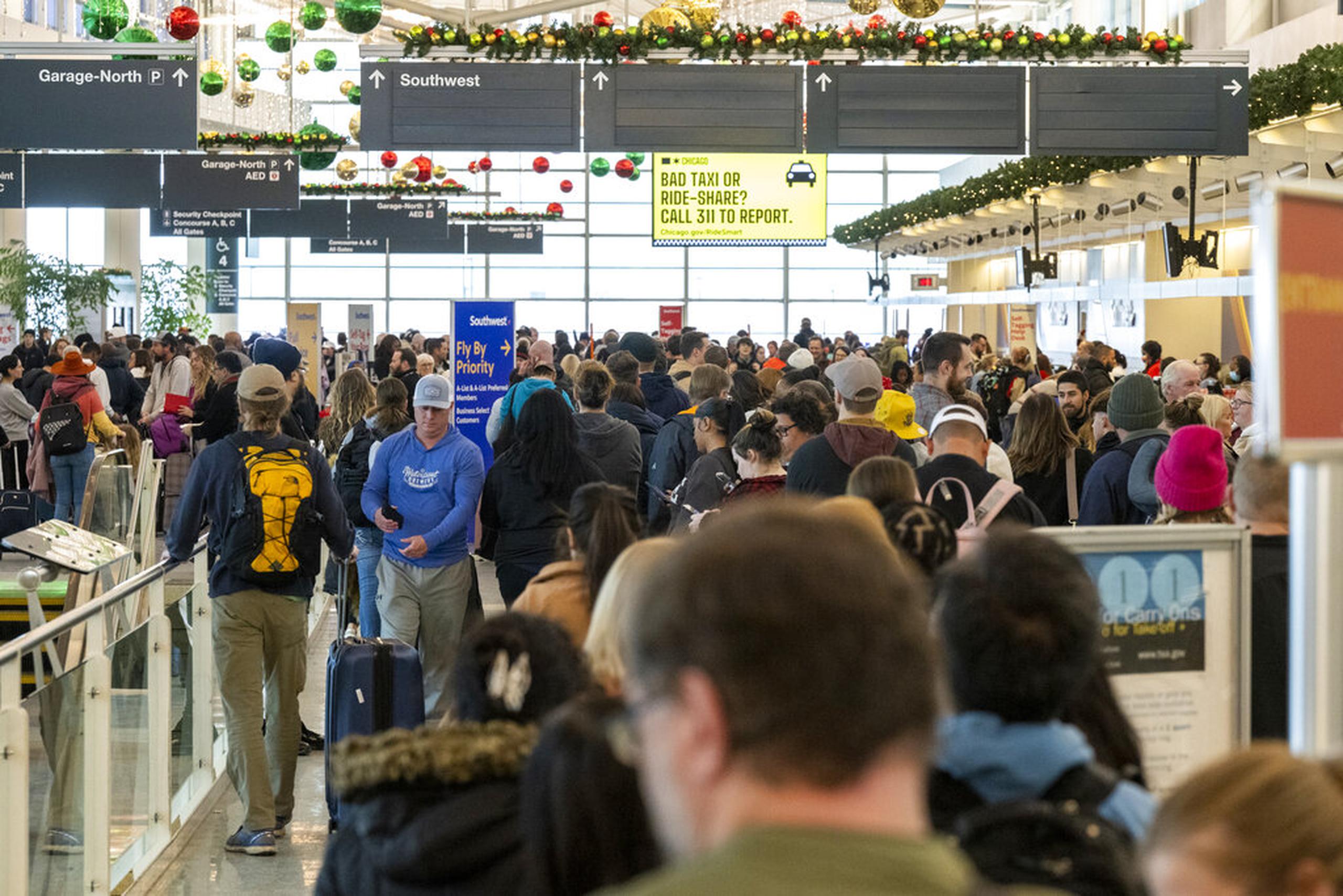 Cientos de personas hacen fila en el "gate" de Southwest en el Aeropuerto Internacional Midway de Chicago el 26 de diciembre de 2022.
