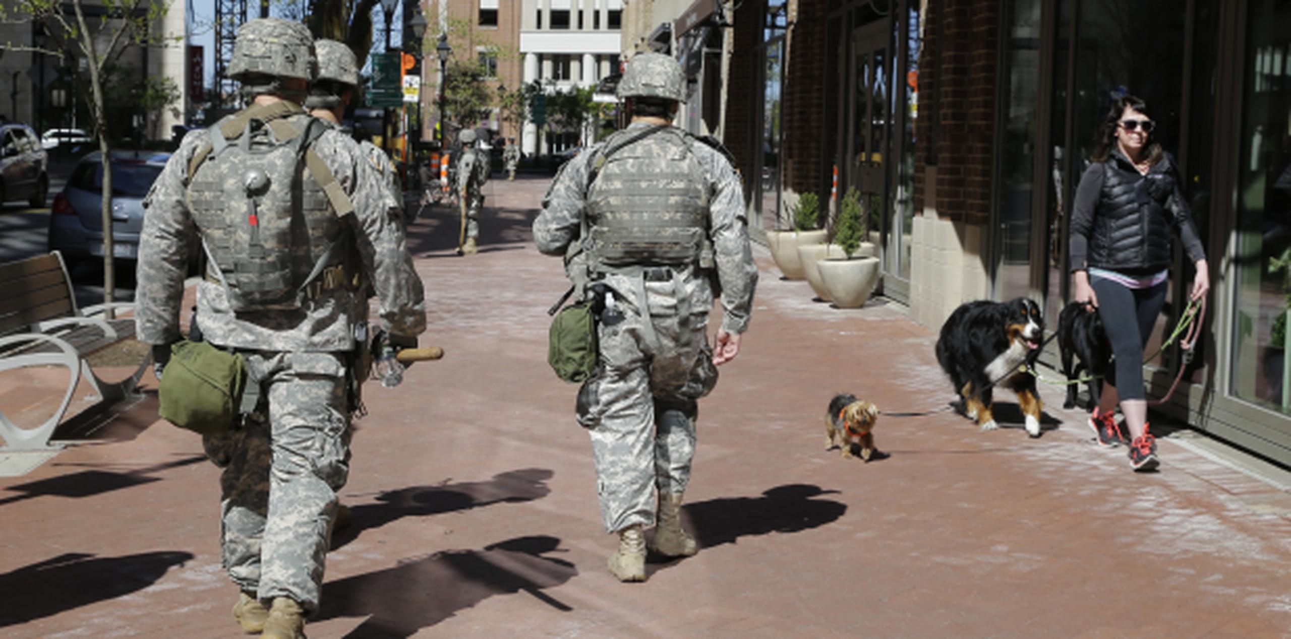 El patrullaje de la Guardia Nacional por las calles de Baltimore no impide a esta residente sacar a pasear a sus perros. (AP)