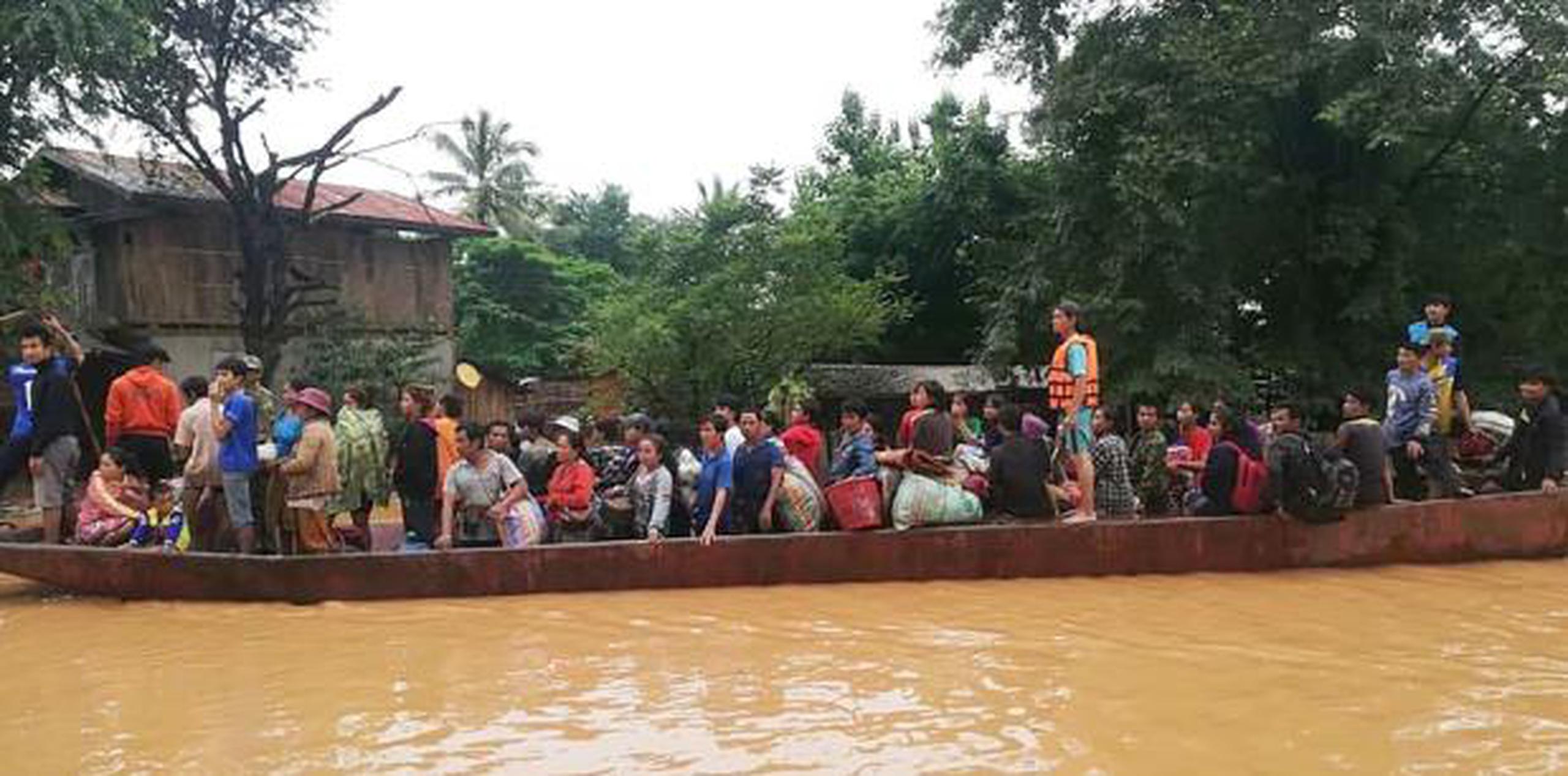 Fotos y vídeos publicados en redes sociales mostraron a los residentes sentados en los tejados para huir de la crecida, mientras otros eran rescatados en barco. (EFE / ABC Laos News)