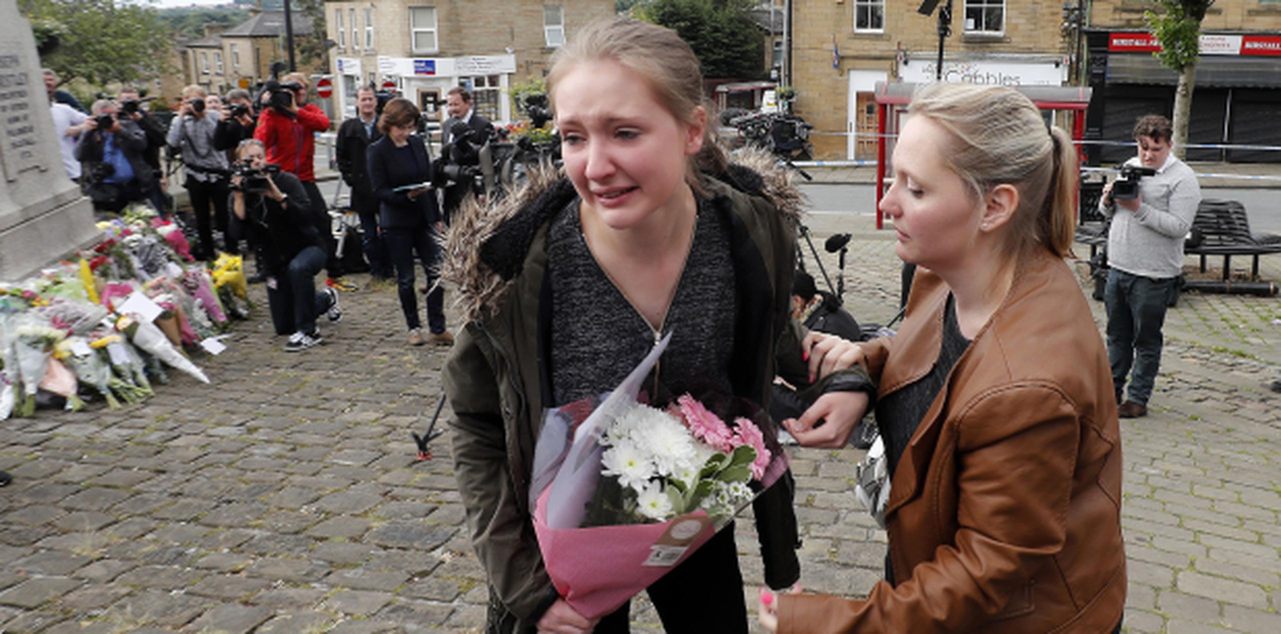 Una joven llora antes de dejar flores en Birstall, West Yorkshire, en honor a Jo Cox. (Prensa Asociada)