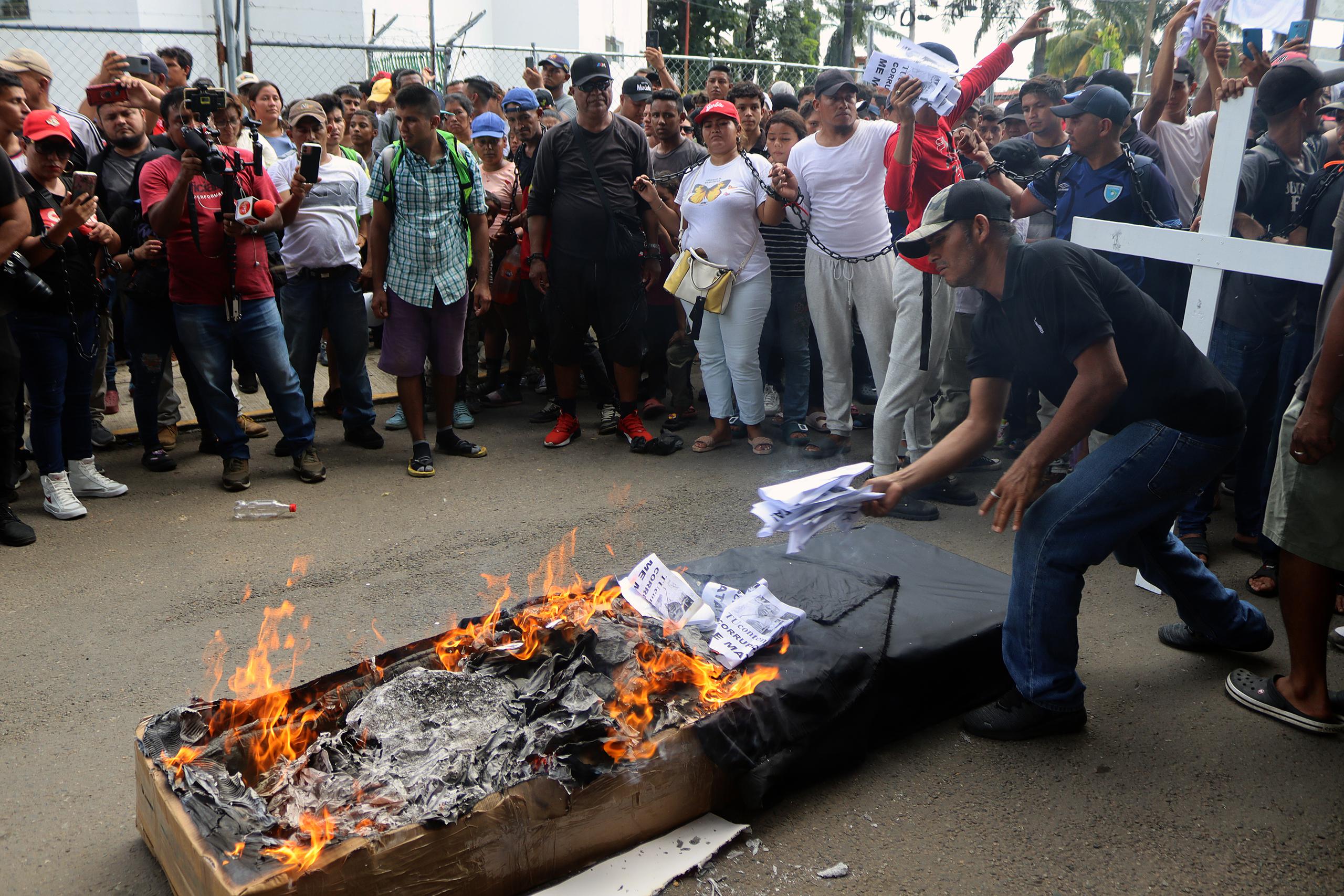 Los migrantes quemaron un ataúd de color negro que representa los migrantes fallecidos en México.