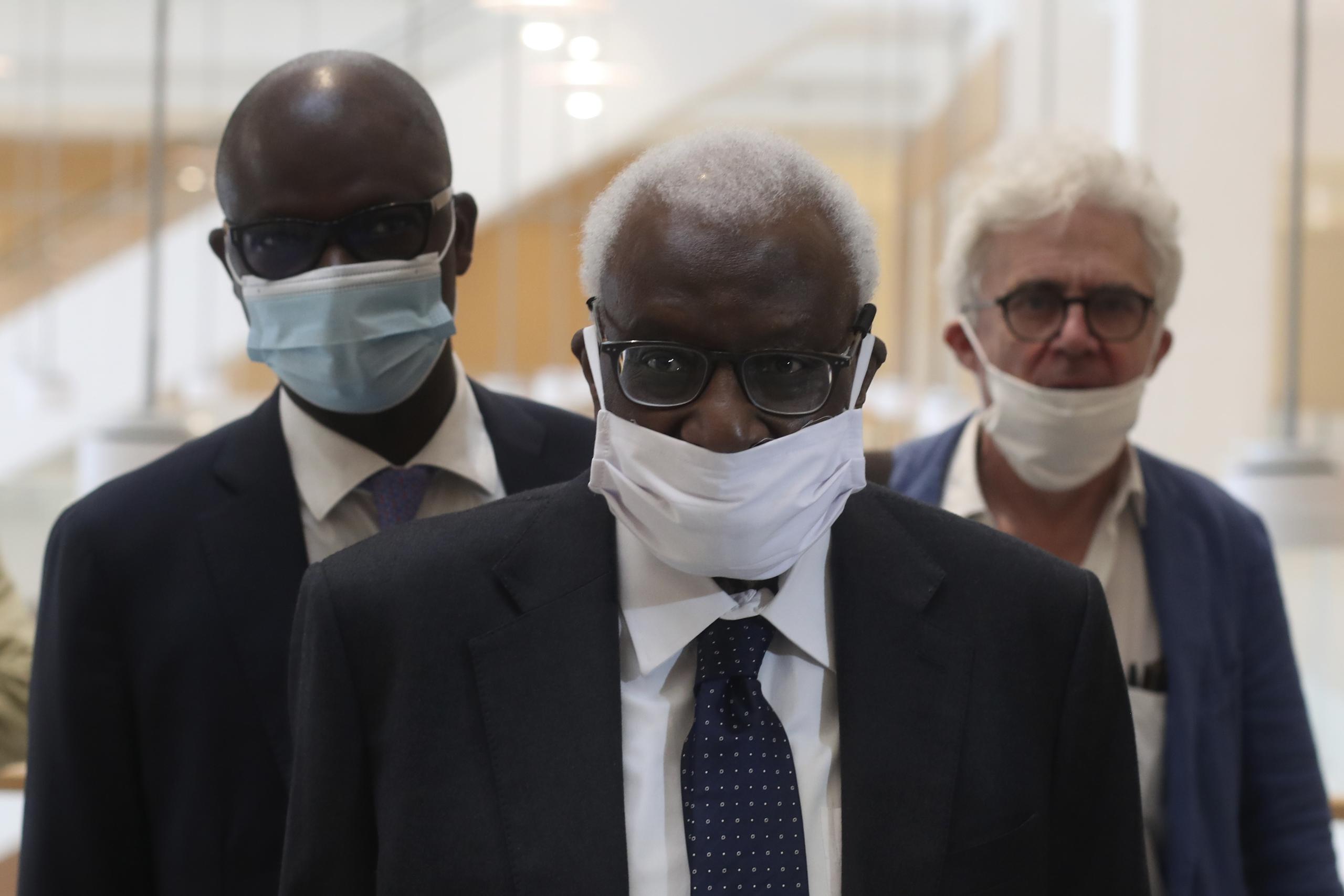 El expresidente de la federación internacional de atletismo Lamine Diack (centro) llega al juzgado de París donde el lunes 8 de junio del 2020 comenzó el juicio por corrupción en la cúpula del organismo.