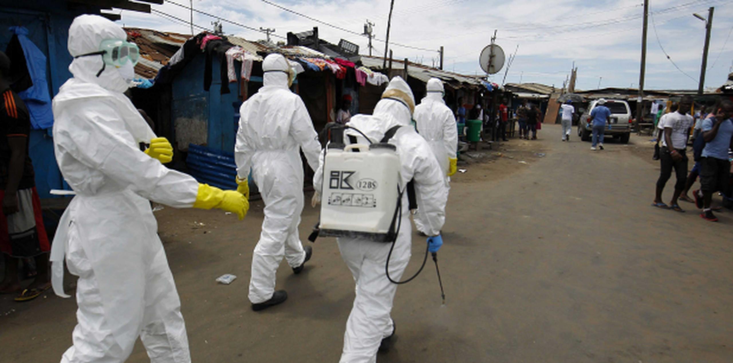 Miembros de la sanidad se disponen a desinfectar la zona donde trasladaron a un paciente que supuestamente padece ébola en la ciudad de Monrovia, Liberia. (EFE)