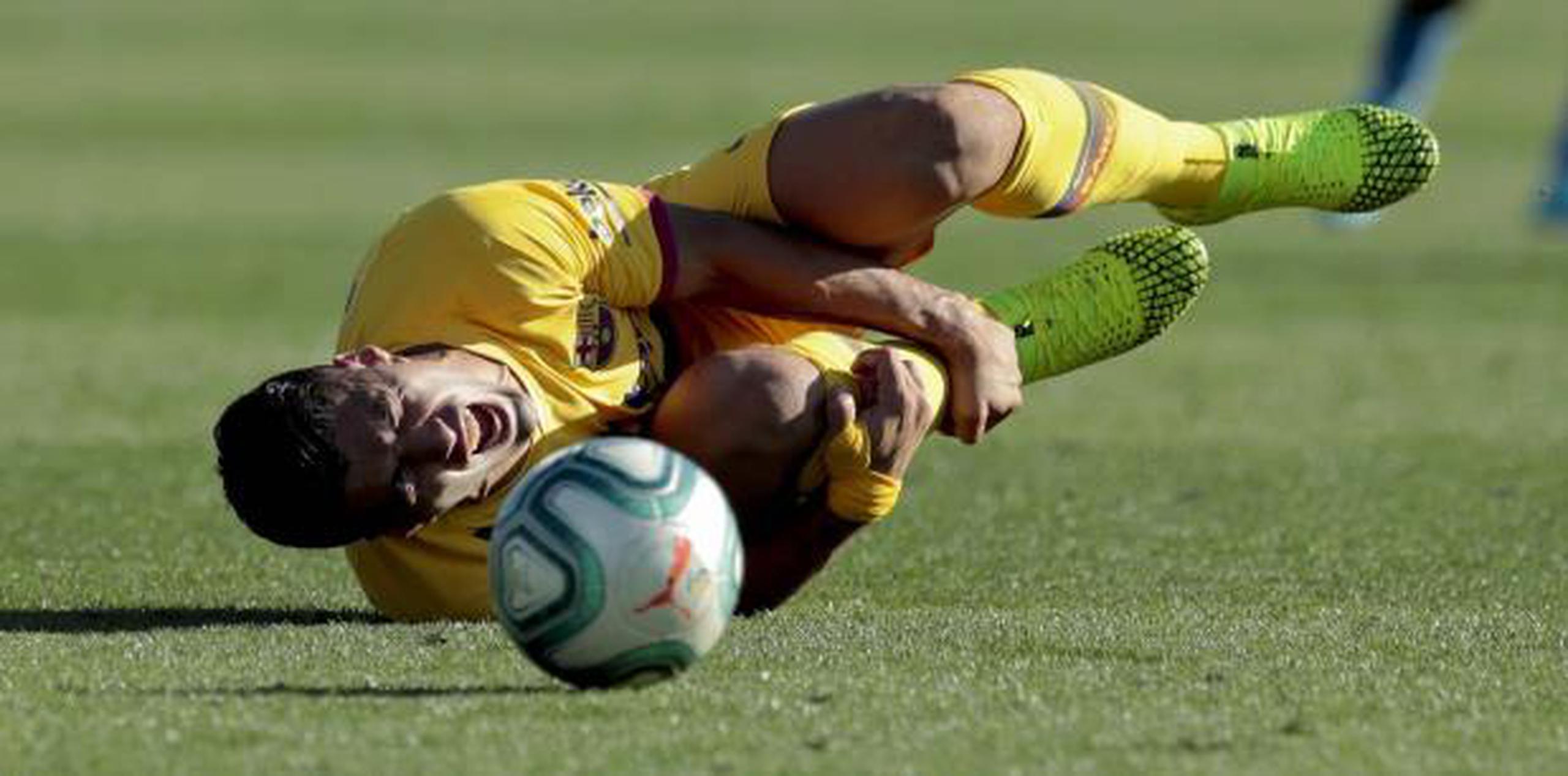 El uruguayo Luis Suárez da muestras de dolor tras recibir un golpe durante el partido del sábado entre Barcelona y Getafe. (AP)