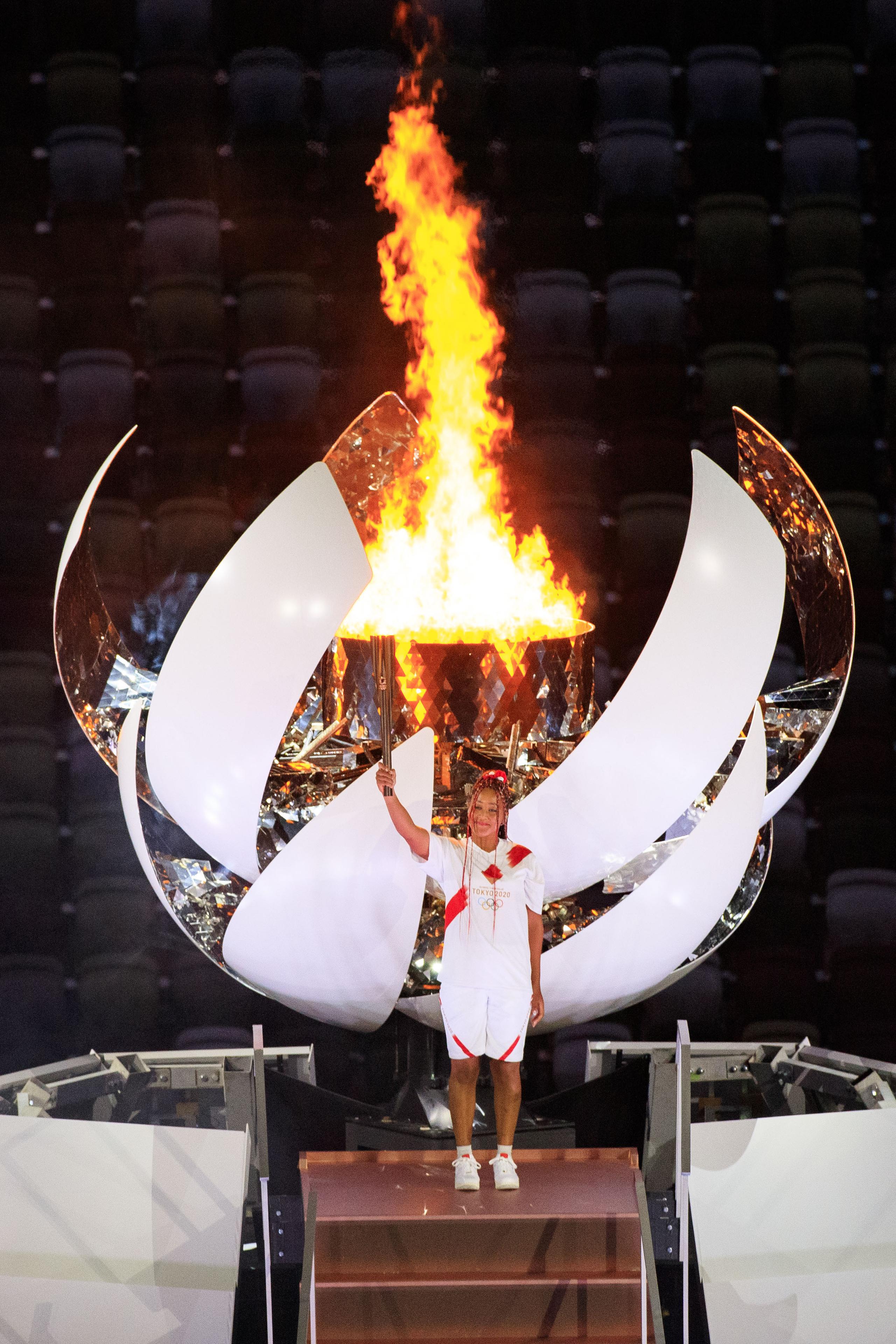 La tenista japonesa Naomi Osaka posa con la antorcha olímpica luego de encender el pebetero de los Juegos Olímpicos de Tokio 2021 el viernes en la noche.
