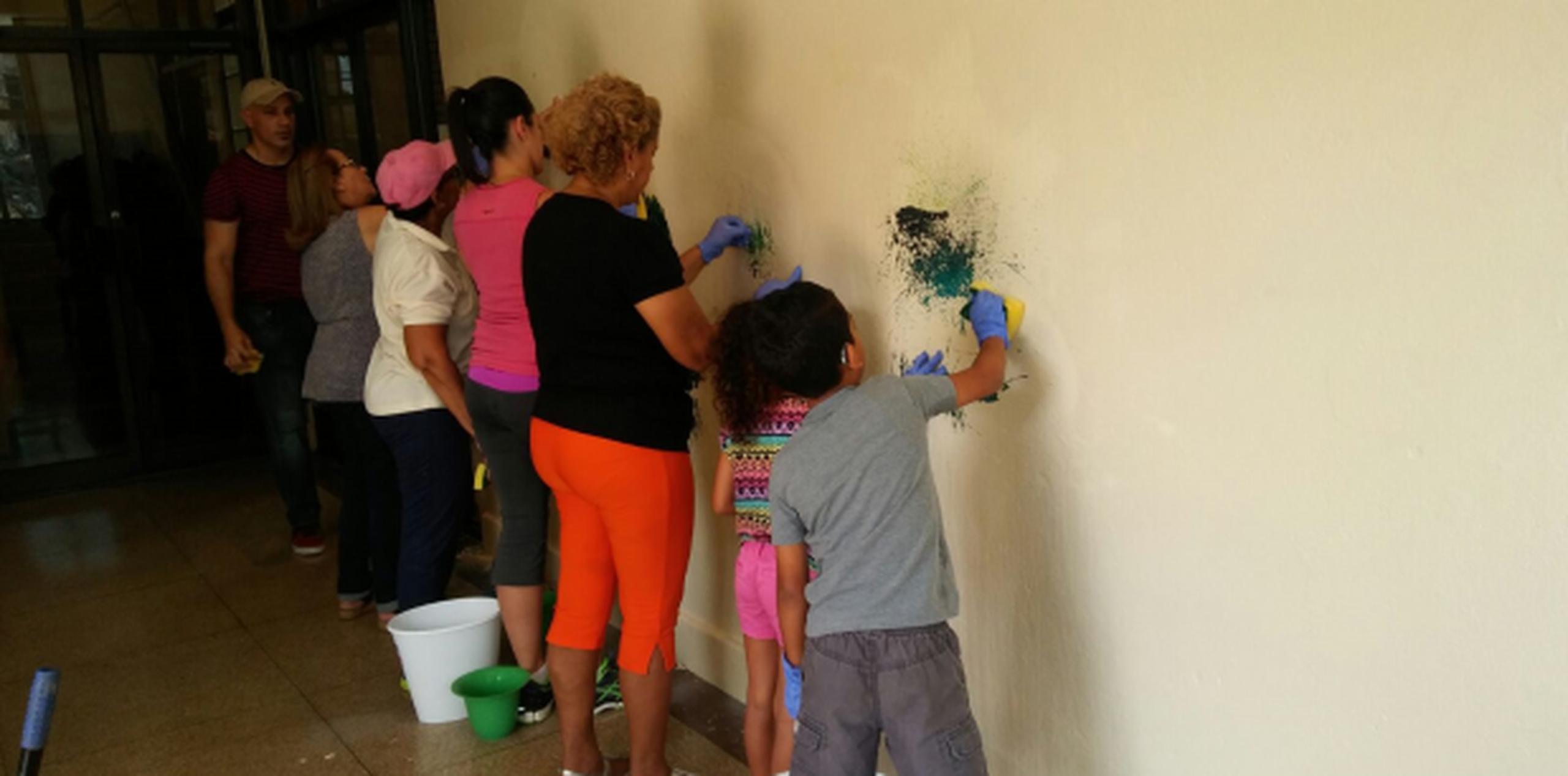 La artista Rosa Rivera, junto a un grupo de voluntarios, se han encargado de remover parte de la pintura. (Suministrada)