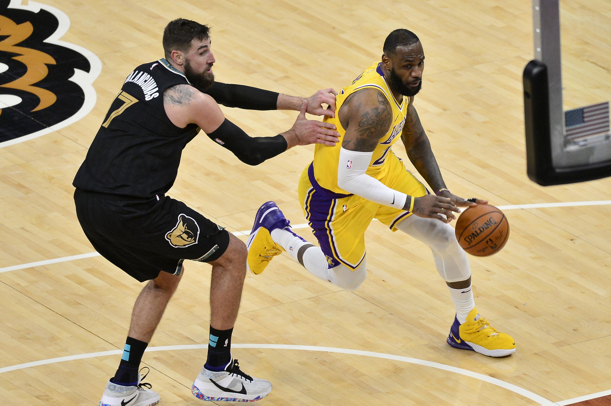 LeBron James, de los Lakers, intenta dejar atrás al centro de los Grizzlies, Jonas Valanciunas (17) en la segunda mitad del partido del martes.