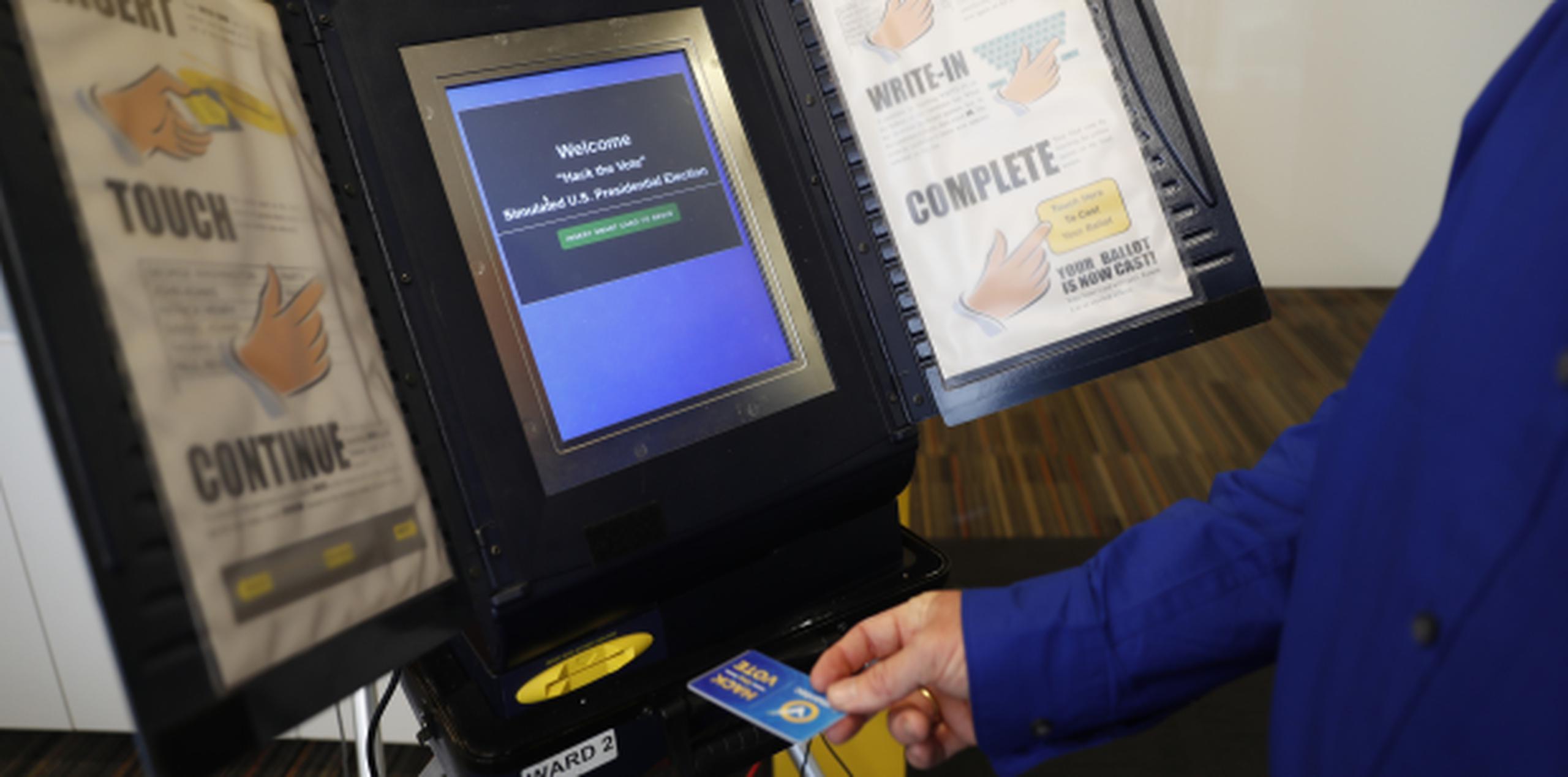 Brian Varner, un investigador de Symantec, inserta una tarjeta con un chip identificador en una máquina de voto electrónico para demostrar cómo 'hackearla'. (AP)