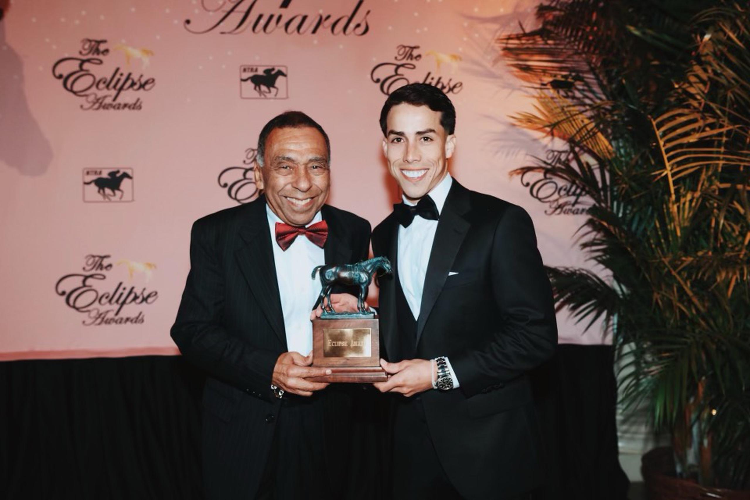 El legendario Ángel 'Junior' Cordero y el estelar Irad Ortiz sostienen un premio Eclipse durante la más reciente entrega de este galardón.