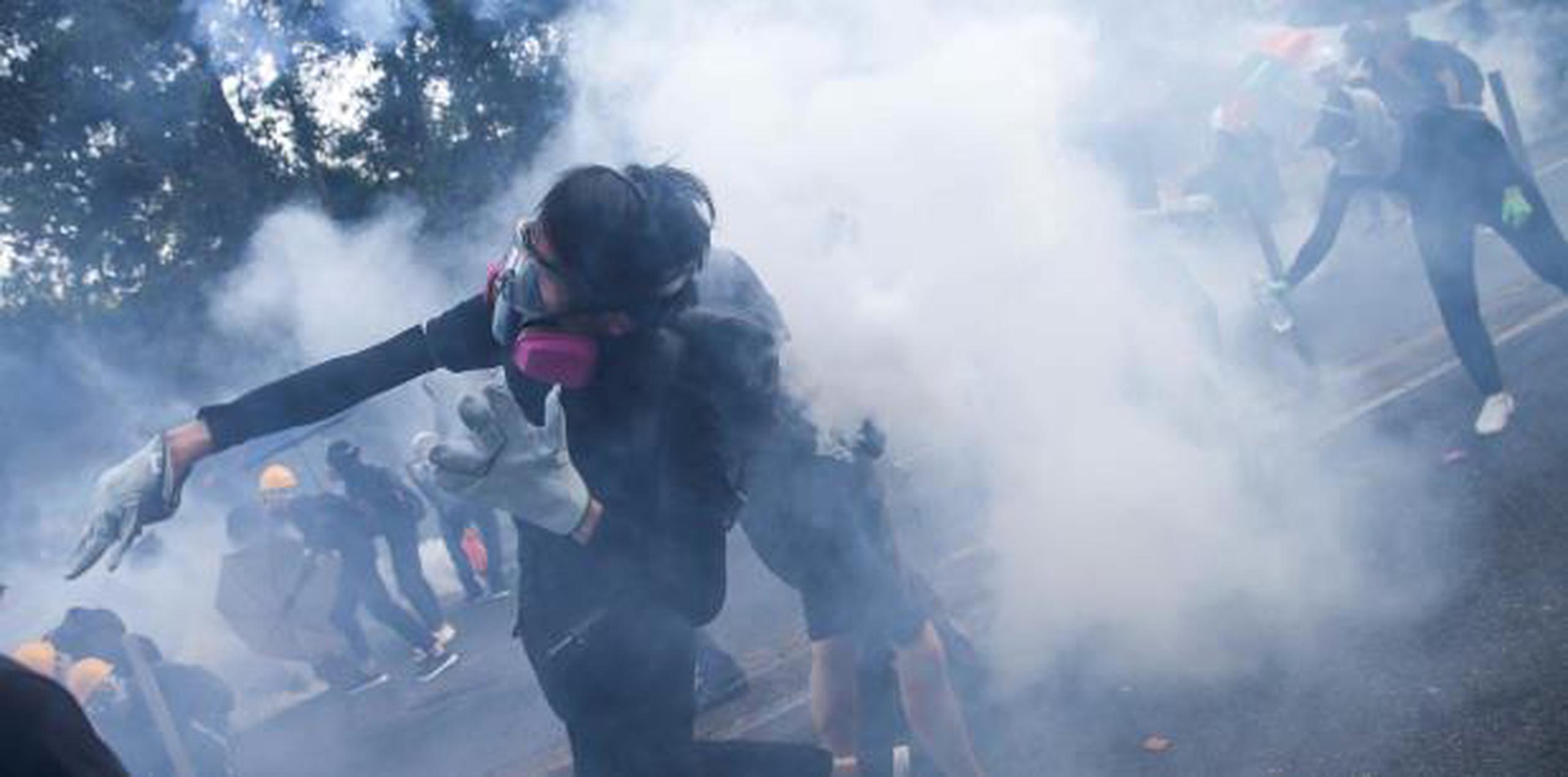 La policía antimotines lanzó varias rondas de gas lacrimógeno en al menos cuatro puntos del territorio semiautónomo chino, mientras agentes y manifestantes entablaban persecuciones que convirtieron las calles en campos de batalla.  (AP)