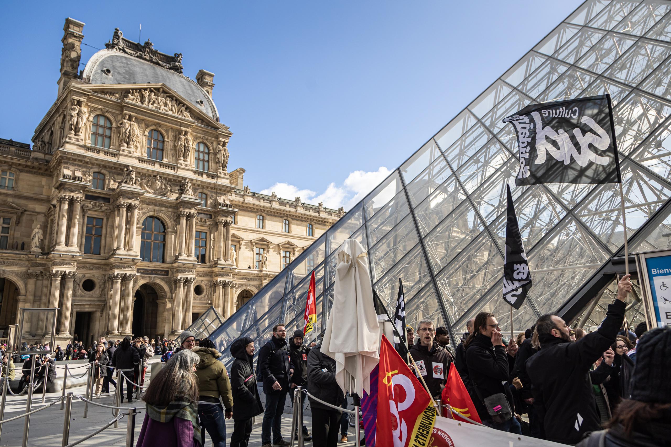 Los empleados del Museo del Louvre bloquean la entrada del museo durante una manifestación frente a la Pirámide del Louvre para protestar contra la reforma de las pensiones del gobierno en París, Francia, el 27 de marzo de 2023. EFE/EPA/CHRISTOPHE PETIT TESSON
