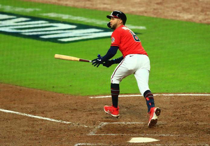 Eddie Rosario pega un hit contra los Astros en el tercer juego de la Serie Mundial en Atlanta.
