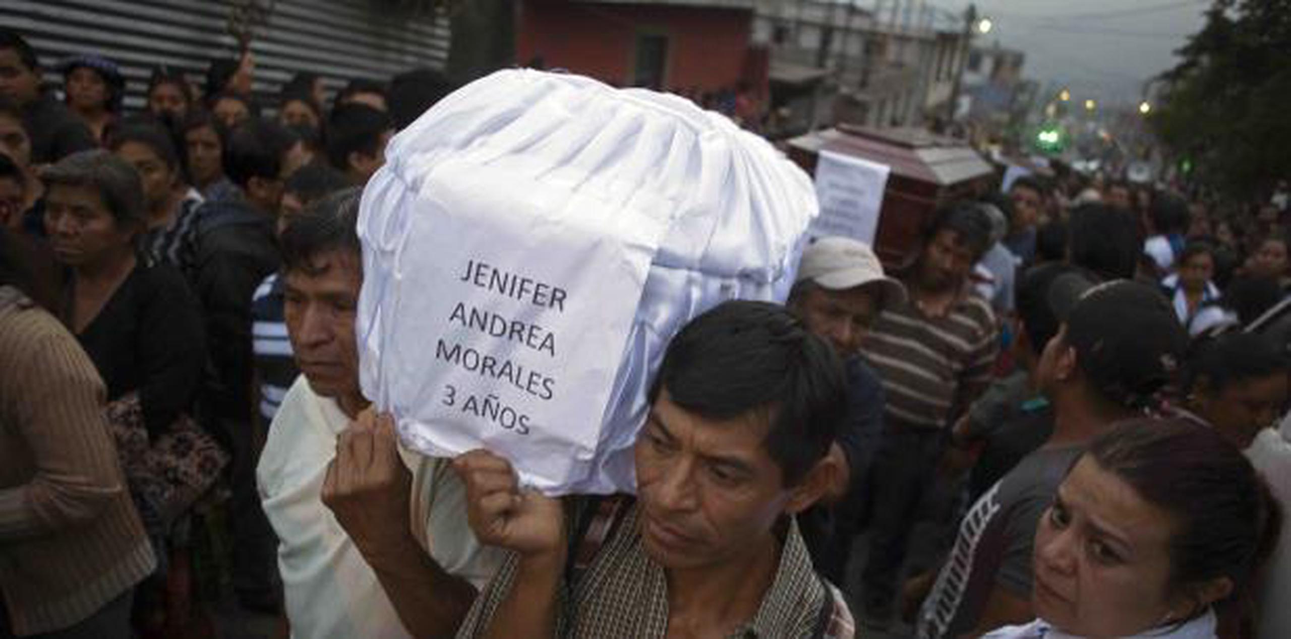 Personas cargan el ataúd de Jennifer Andrea Morales, de tres años, durante el funeral de siete víctimas de la erupción del Volcán de Fuego. (AP / Luis Soto)