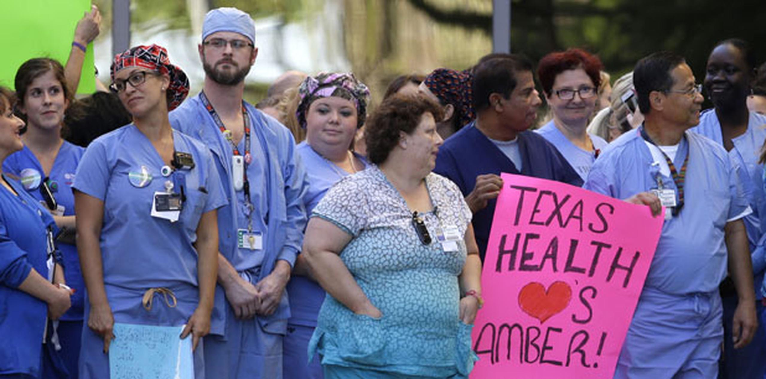 Compañeros de trabajo de Amber Vinson, una de las dos enfermeras contagiadas de ébola en el Hospital Presbiteriano de Dallas, esperan la salida de Vinson una vez dada de alta. (AP)