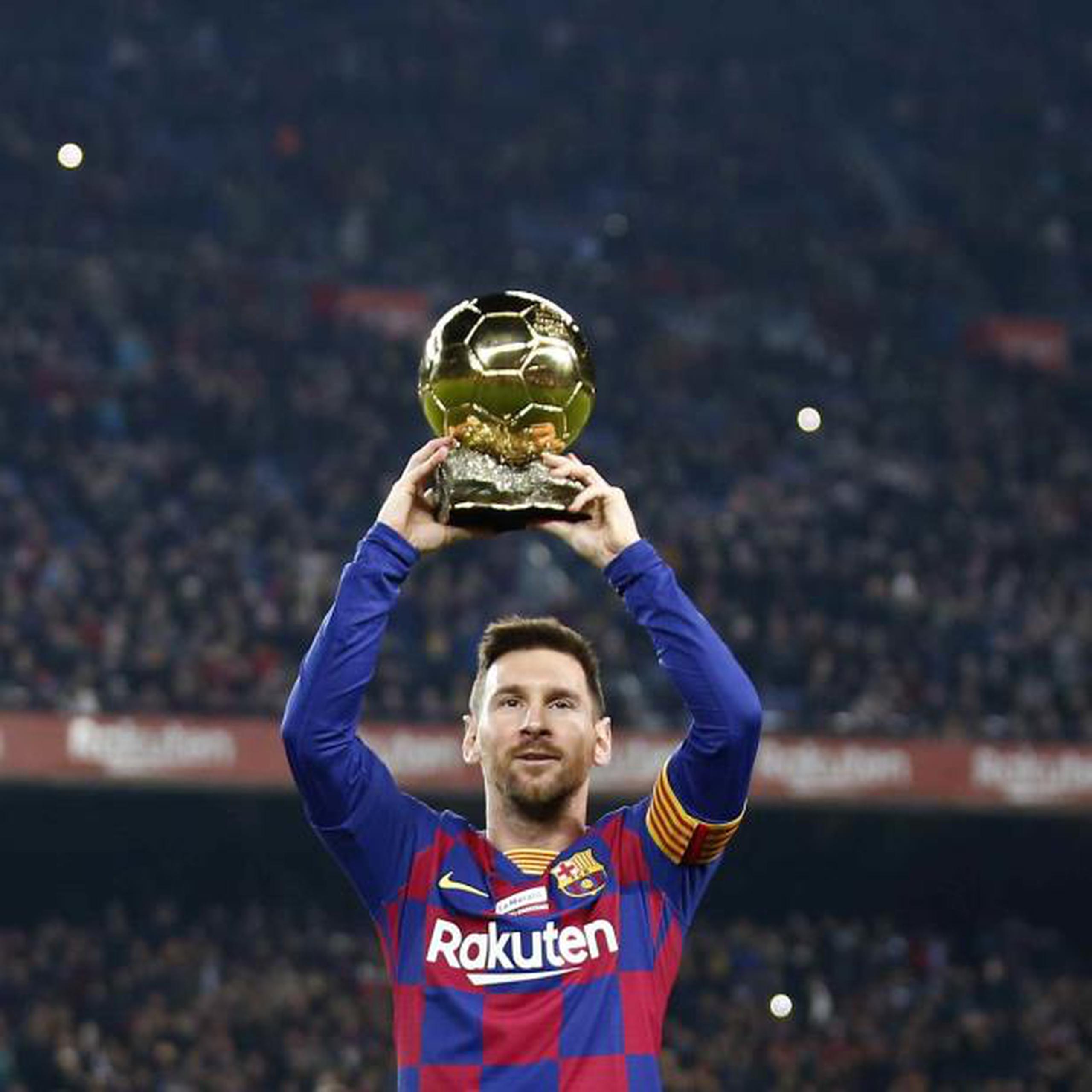 Lionel Messi muestra su más reciente Balón de Oro a la afición en el Camp Nou. (AP)
