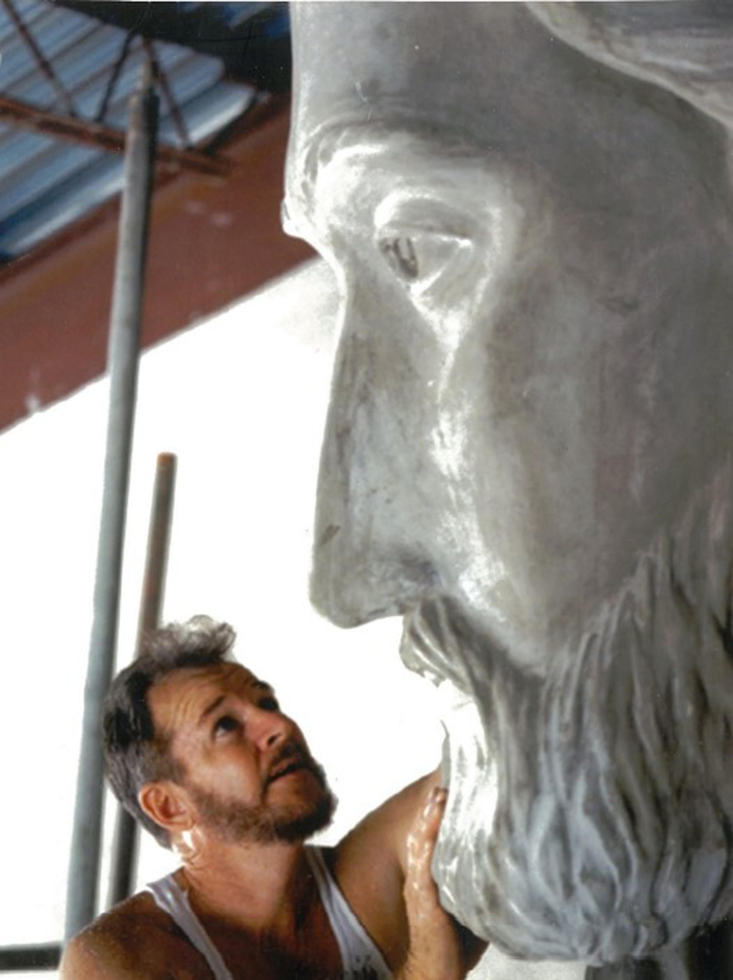 El escultor durante el proceso de creación de la enorme pieza religiosa.