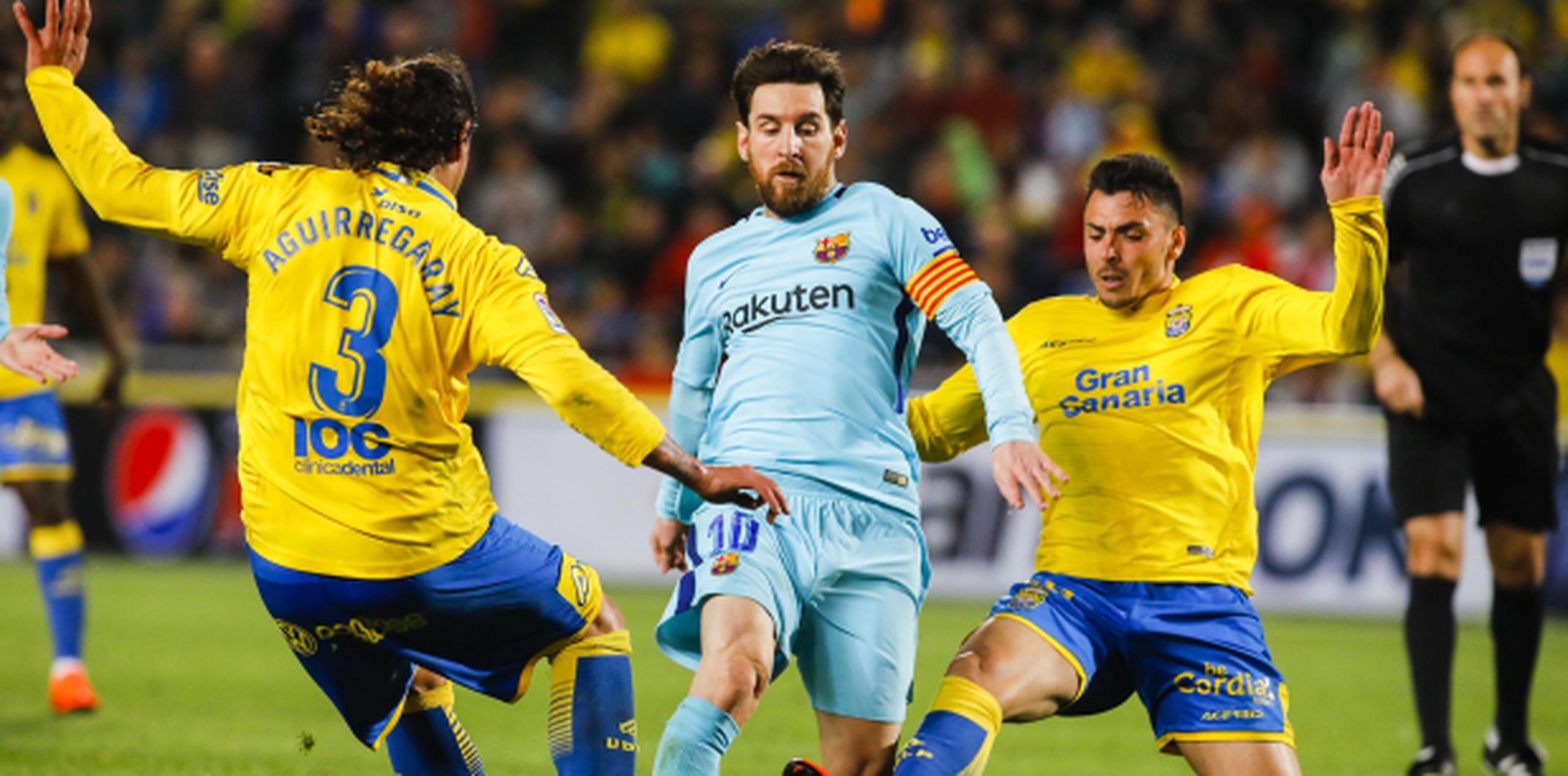 El astro de Barcelona Lionel Messi, al centro, se disputa el balón con los jugadores de Las Palmas Matías Aguirregaray, izquierda, y Ximo Navarro, en un partido de La Liga española el jueves, 1 de marzo del 2018. (AP Foto/Lucas de León)