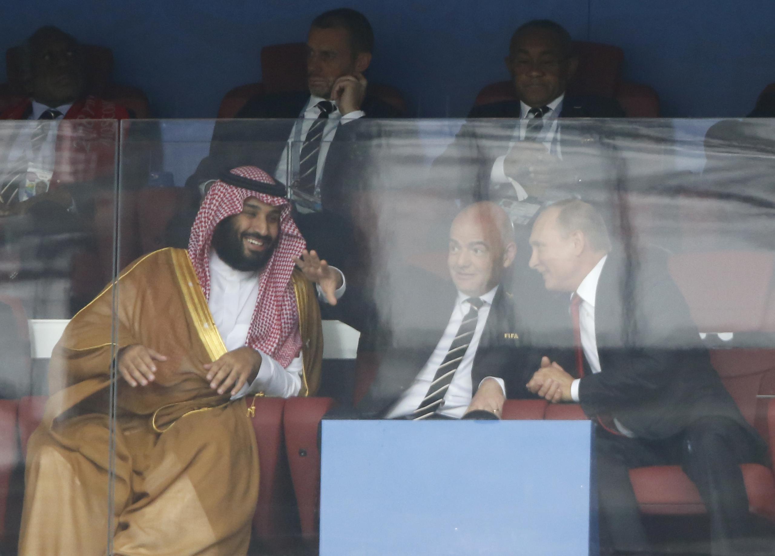 El príncipe heredero de Arabia Saudí, Mohammed bin Salman (izquierda), el presidente de la FIFA Gianni Infantino (centro) y el presidente de Rusia Vladimir Putin conversan durante el partido inaugural entre Rusia y Arabia Saudí en la Copa Mundial de 2018, en el estadio de Luzhniki, en Moscú, el 14 de junio de 2018.