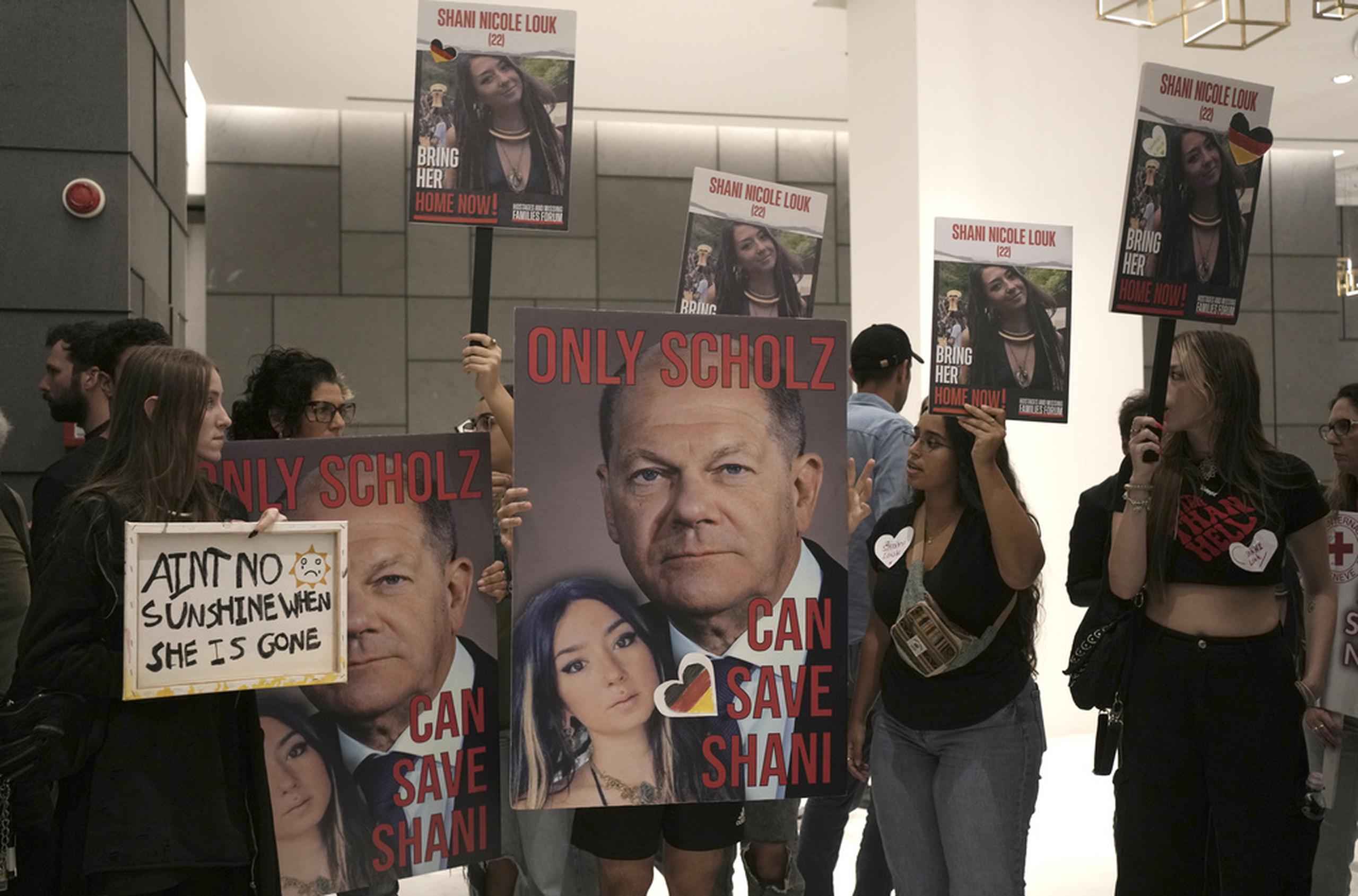 Partidarios de la joven Shani Louk sostienen pancartas pidiendo que el canciller alemán Olaf Scholz ayude con su regreso, antes de confirmarse su asesinato, el 17 de octubre de 2023 en la embajada alemana en Tel Aviv.