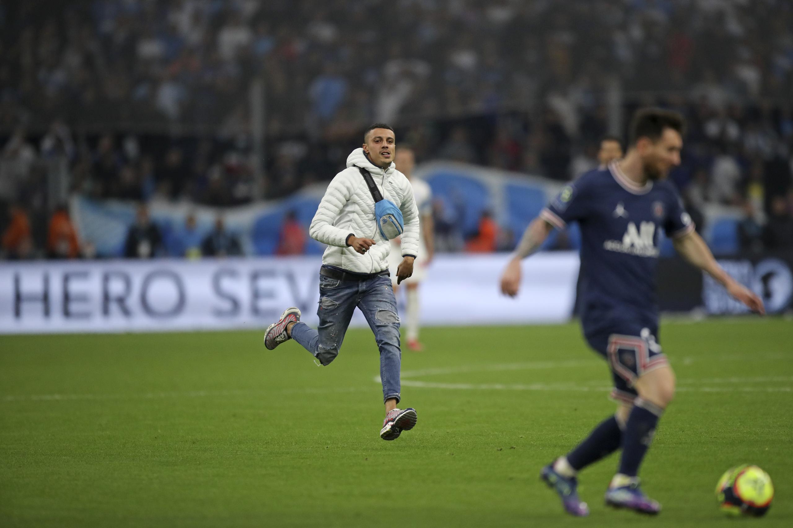 Un individuo corre hacia al delantero del PSG Lionel Messi durante el partido contra el Marsella por la liga francesa.