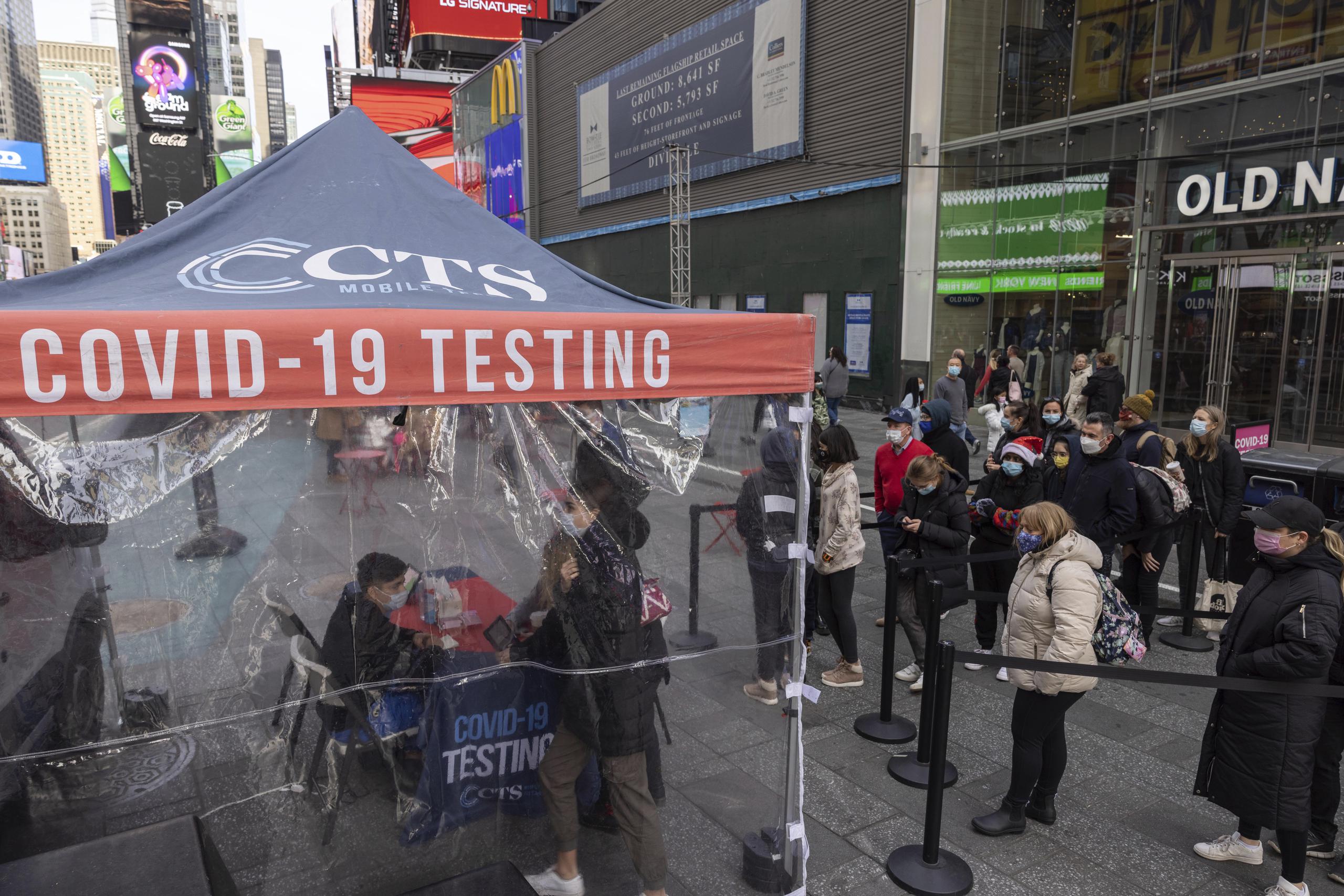 Varias personas hacen fila para que les efectúen una prueba diagnóstica de COVID-19 en un centro móvil en Times Square, en Nueva York. (AP Foto/Yuki Iwamura)