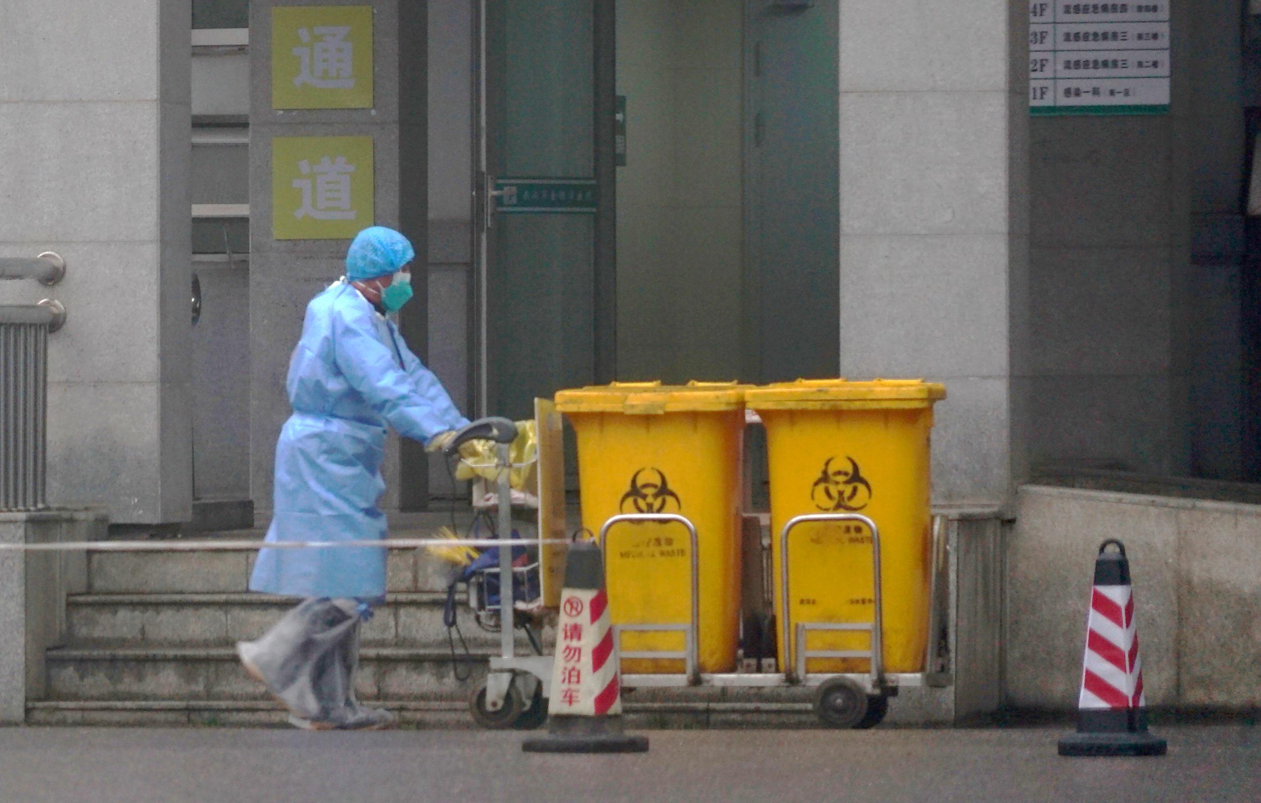 Empleados médicos llevaban trajes protectores afuera del Centro de Tratamientos Médicos de Wuhan, que atiende a algunos pacientes con enfermedades respiratorias virales.