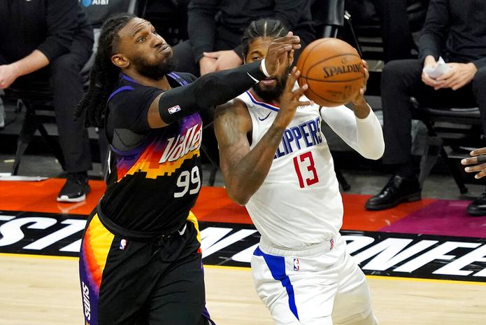 Paul George de los Clippers se prepara para lanzar un pase mientras Jae Crowder de los Suns intenta bloquearlo durante el quinto partido de la final de la Conferencia Oeste de la NBA, el 28 de junio de 2021, en Phoenix.