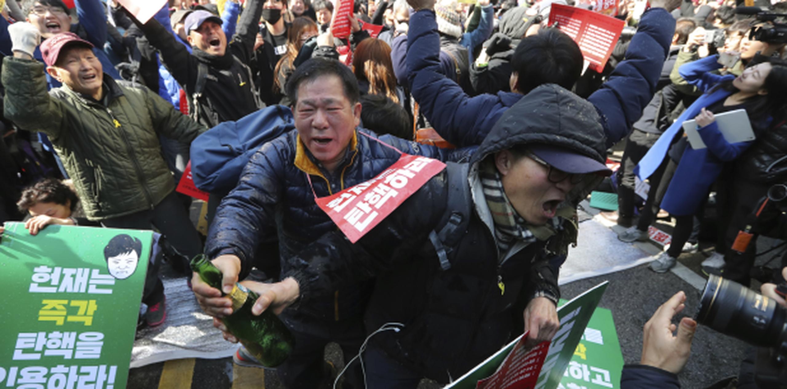 Manifestantes en Seúl celebran la destitución de la presidenta Park Geun-hye en una de las muchas protestas que tuvieron lugar en toda Corea del Sur en las últimas horas. (AP/Lee Jin-man)
