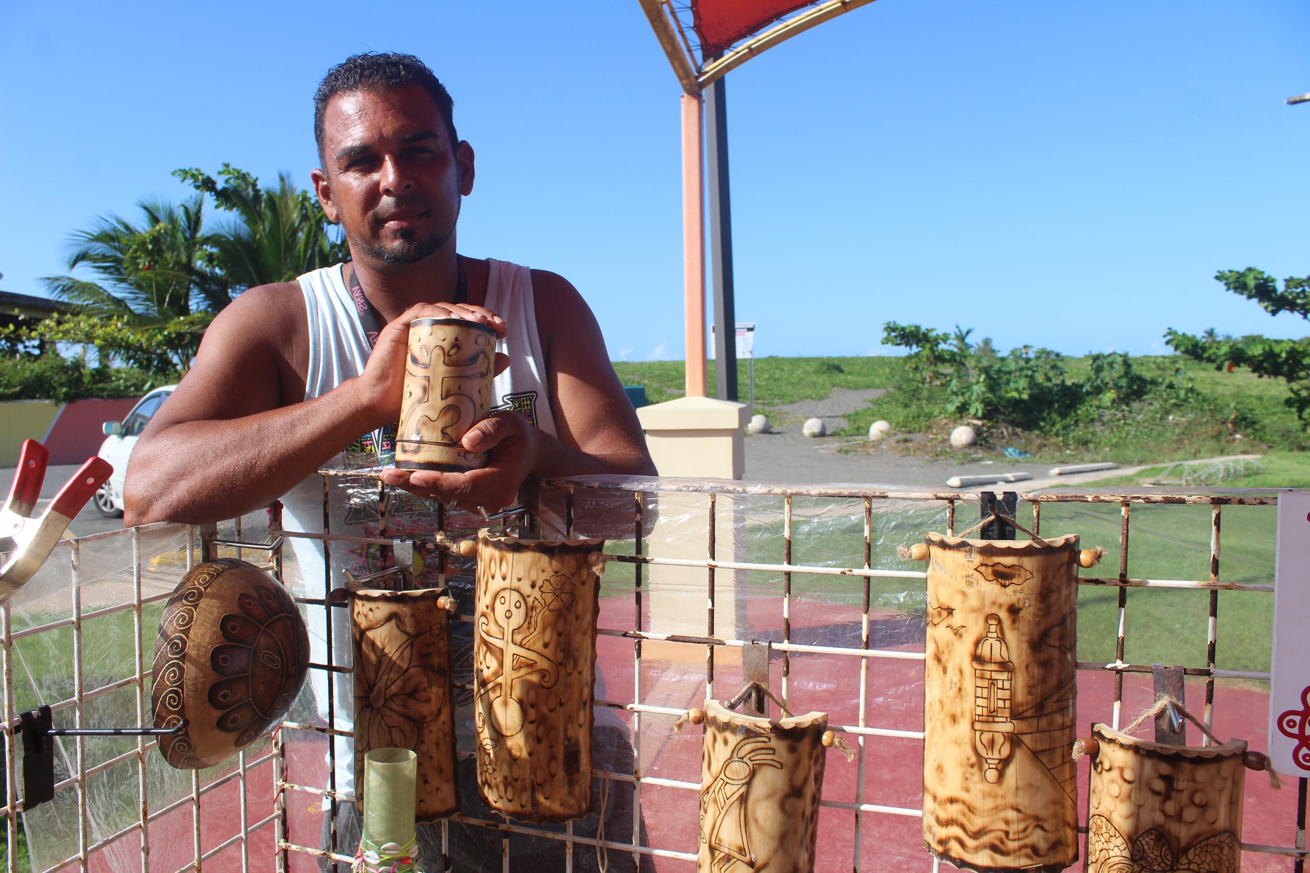 Julio E. Maldonado promueve sus trabajos de pirograbados, tallados en madera y vasos en bambú.