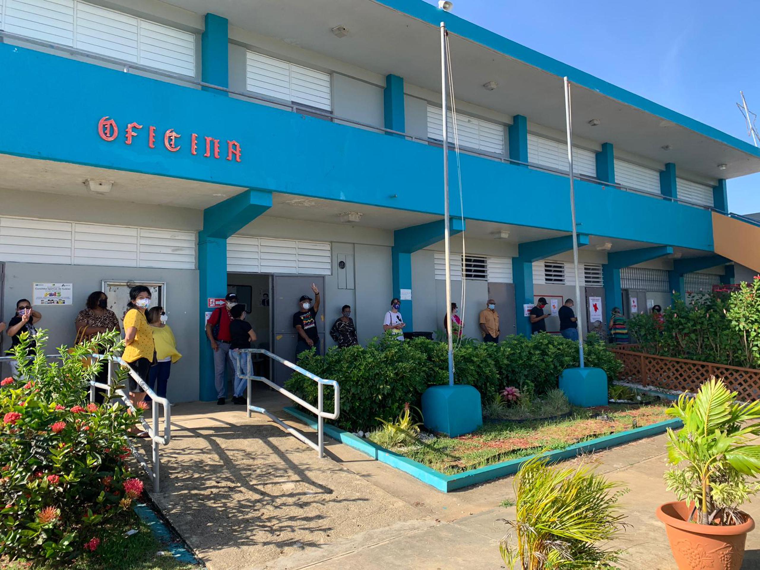 Electores en la escuela Adams, en Aguadilla, esperando por que llegaran las papeletas esta mañana.