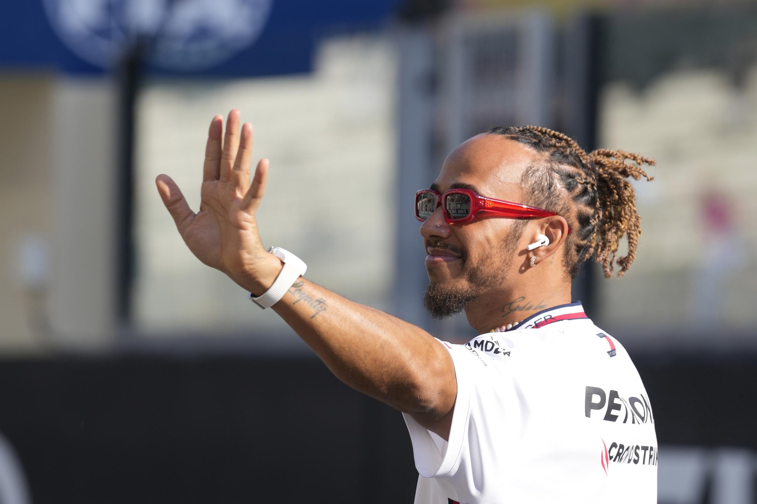 El piloto Lewis Hamilton saluda a la afición mientras los pilotos desfilan antes del Gran Premio de Abu Dhabi.