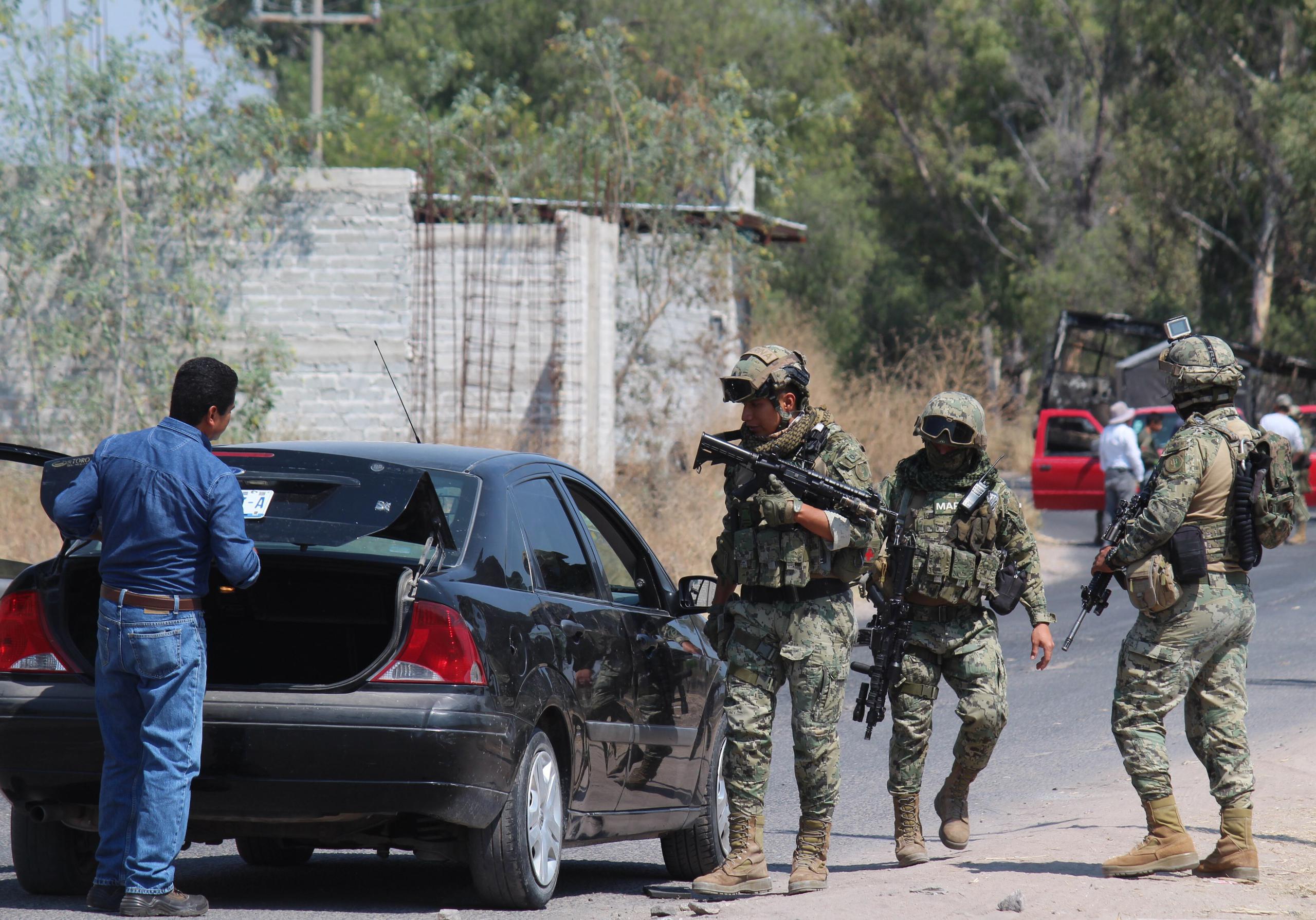 Miembros del ejército mexicano y las fuerzas estatales realizan inspecciones y resguardan zonas de bloqueos, en la comunidad de Santa Rosa de Lima, estado de Guanajuato (México).