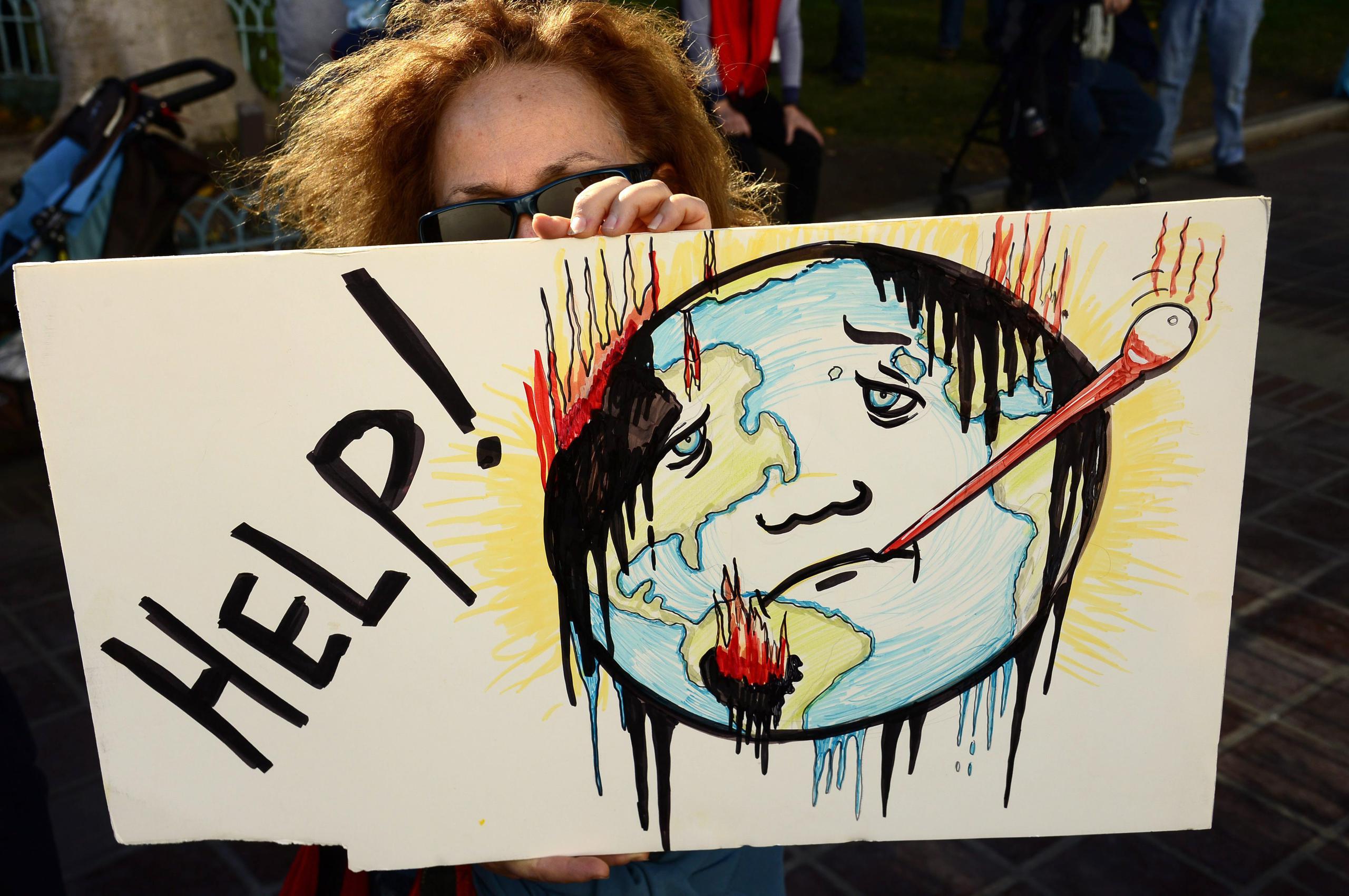 Una mujer durante una protesta antes del acuerdo histórico alcanzado el pasado fin de semana en París para atender el cambio climático. (Archivo)
