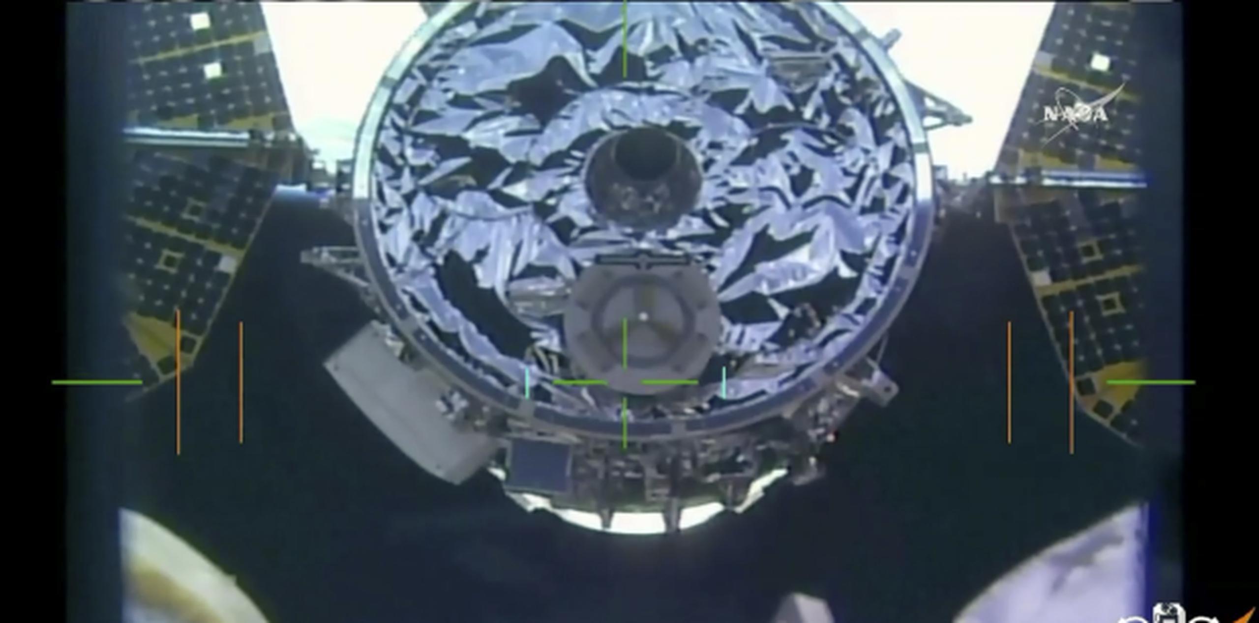 Momento en el que el brazo robótico de la Estación Espacial Internacional se extiende para atrapar la nave de carga que llevó suministros a los astronautas. (NASA TV via AP)
