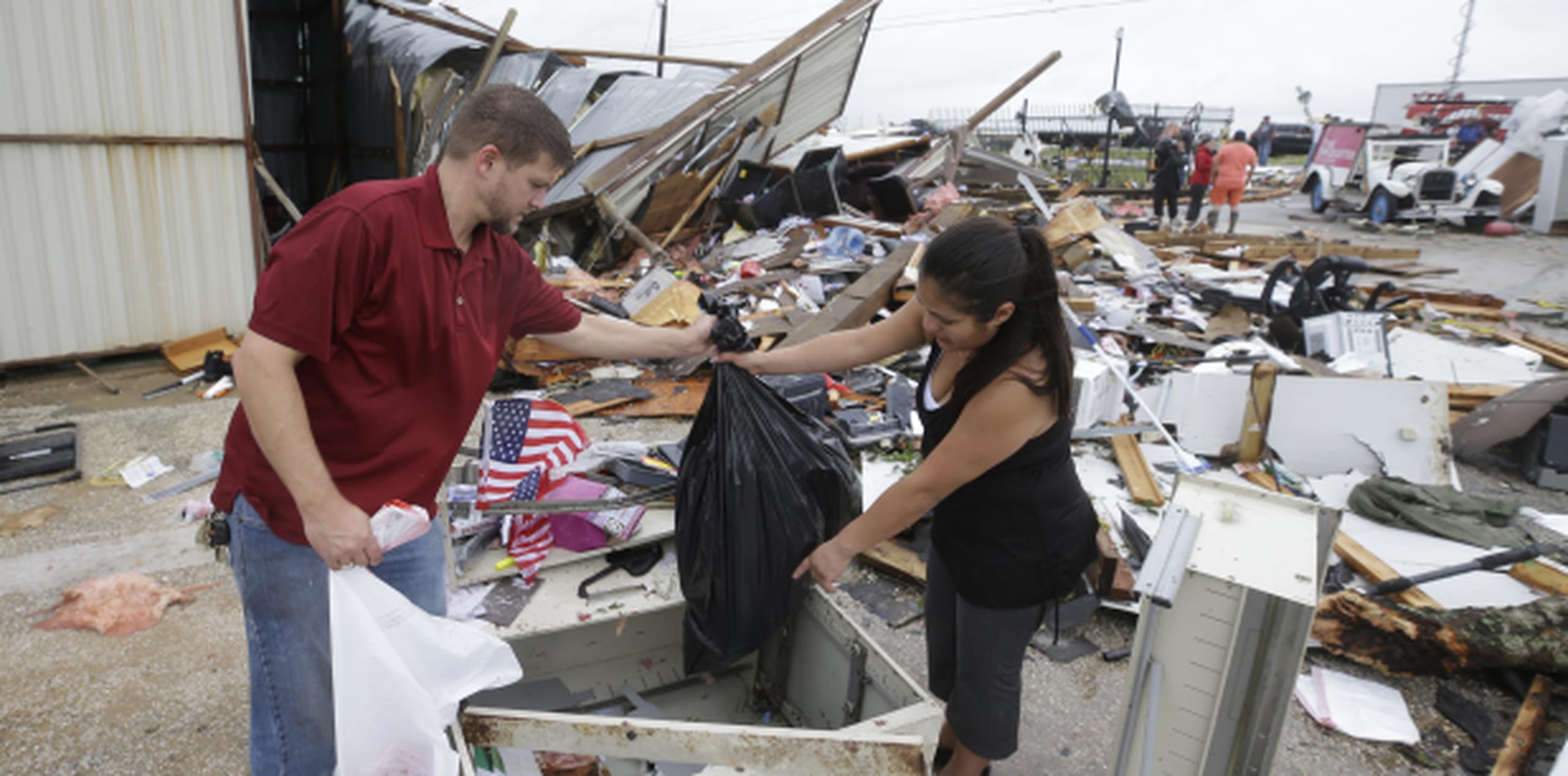 Kenneth Byrant y su esposa, Jennifer, buscan en los escombros del negocio Bryant's Auto Sales en Katy, Texas. (Melissa Phillip / Houston Chronicle vía AP)