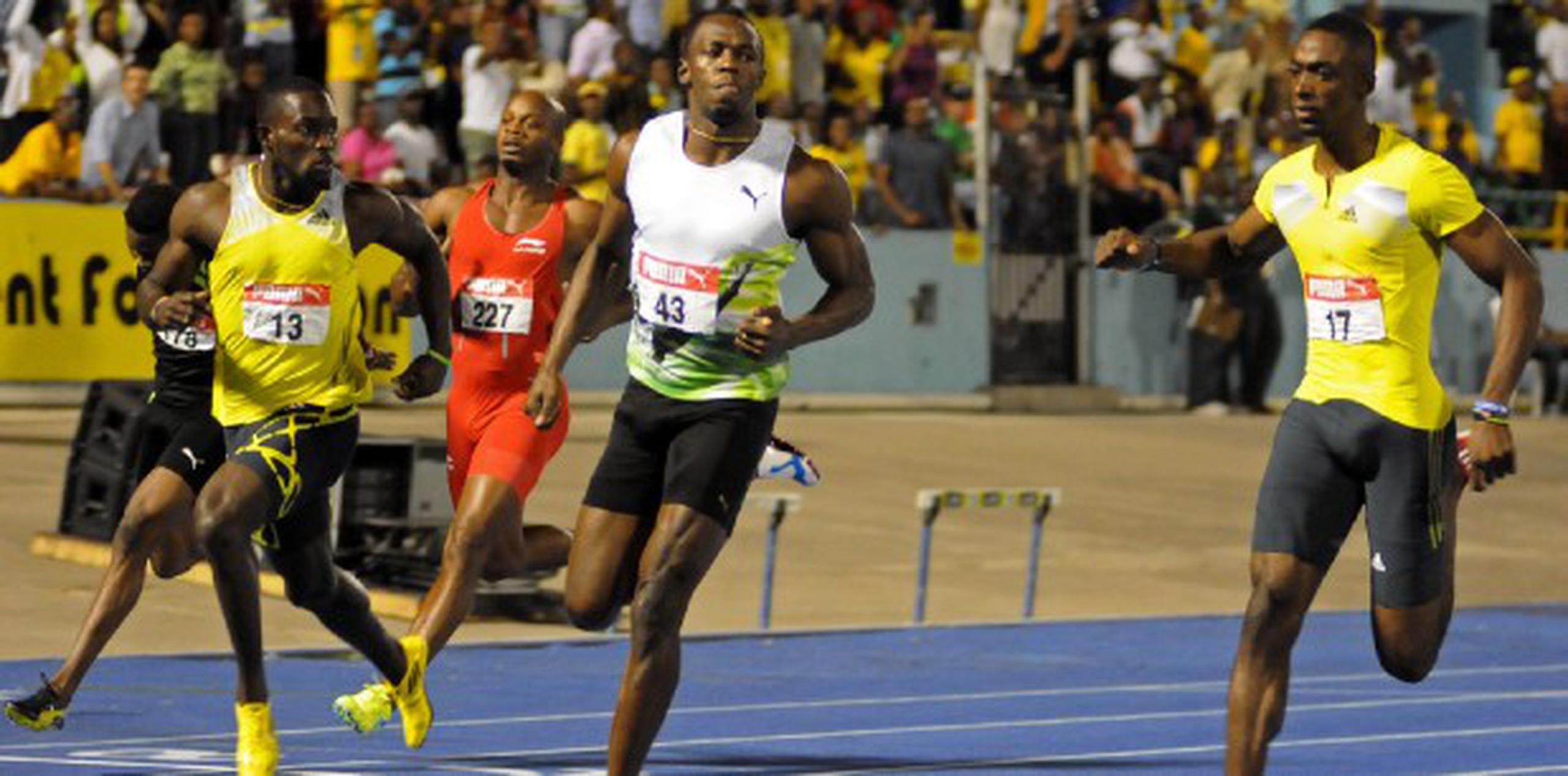 El corredor jamaiquino, Usain Bolt (al centro), cronometró 9.94 segundos en los 100 metros para vencer a sus compatriotas en campeonato nacional de Jamaica. (Collin Reid / AP).