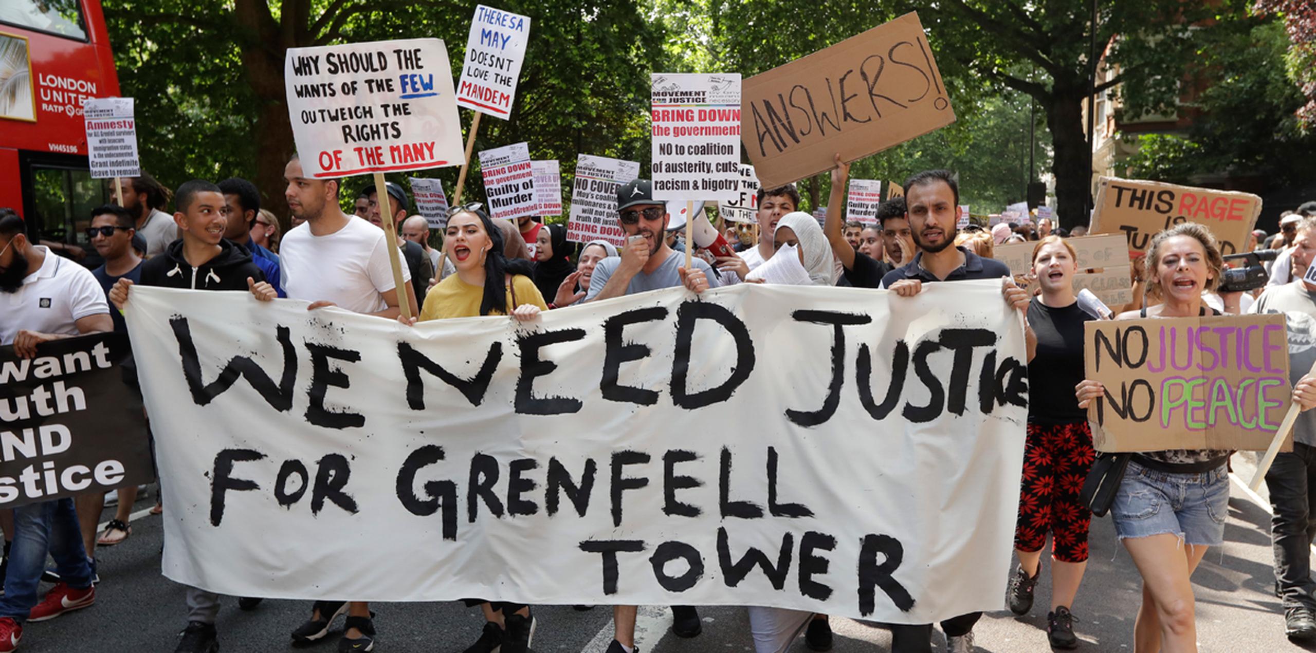 Manifestantes sostienen una pancarta pidiendo justicia para las víctimas del reciente incendio que arrasó la Torre Grenfell, durante una marcha hacia el parlamento de Londres. (AP)