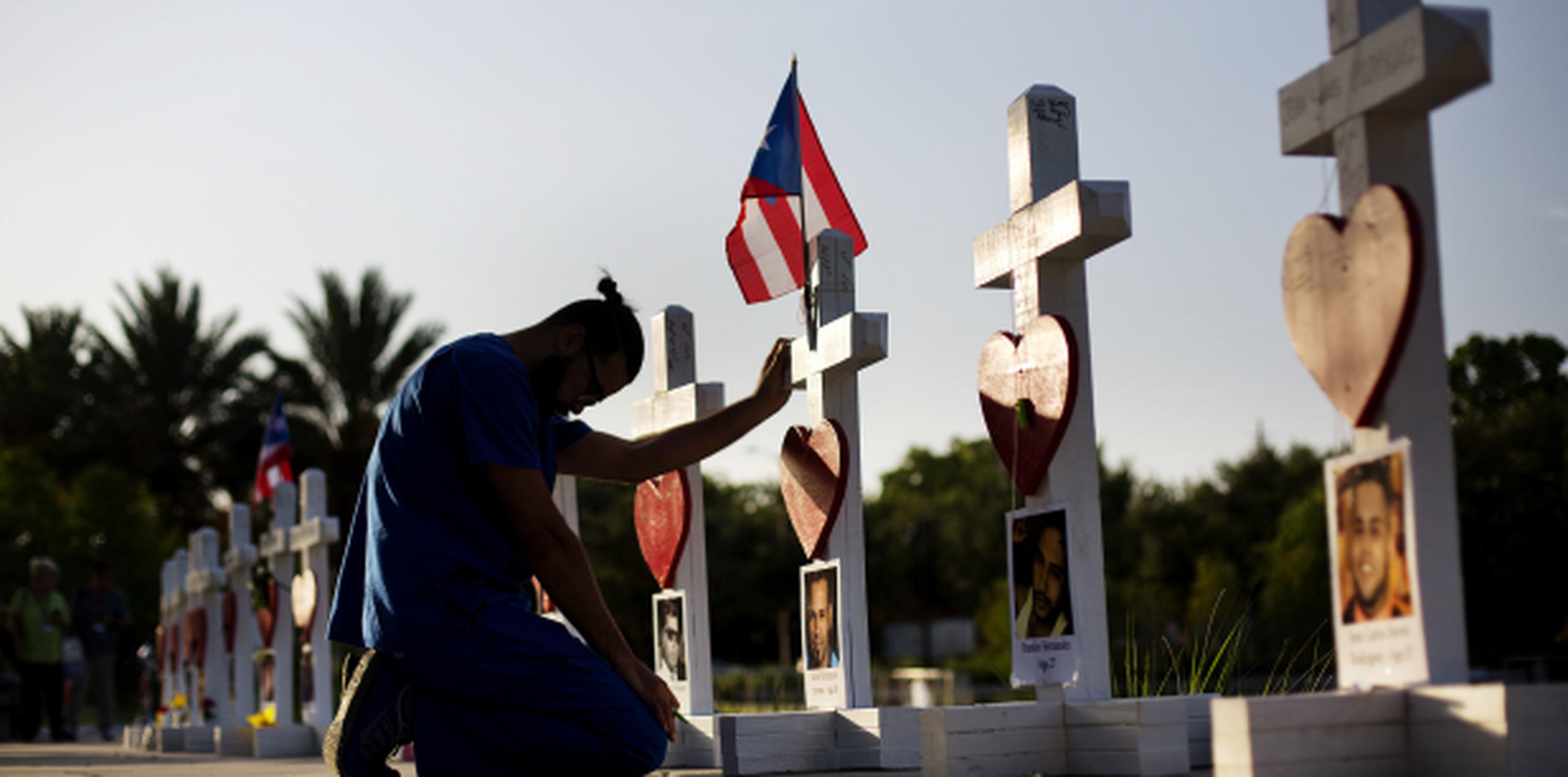 Ernesto Vergne reza en la cruz en hono a Xavier Emmanuel Serrano Rosado y otras víctimas. (Prensa Asociada)