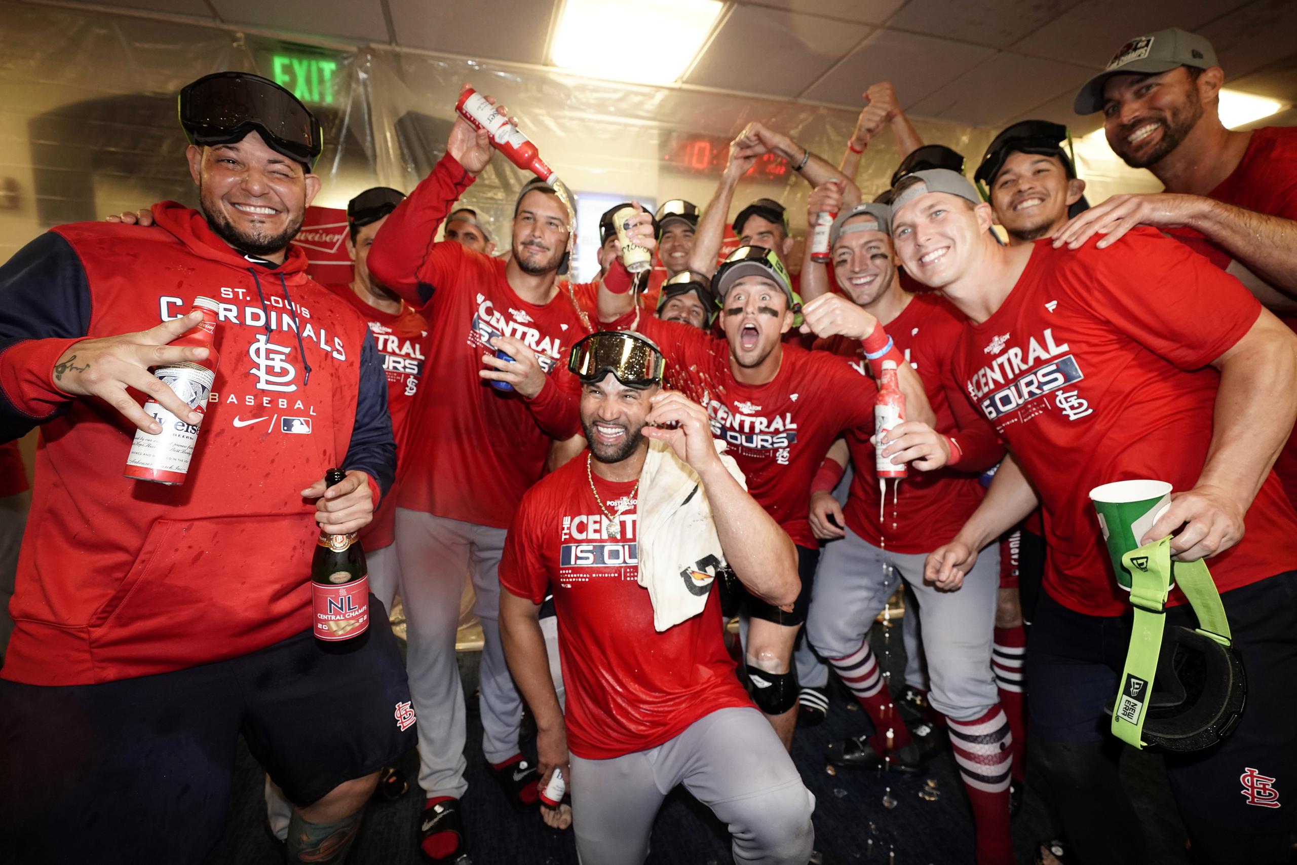 Yadier Molina, a la izquierda, festeja con sus compañeros de los Cardinals de San Luis la corona de la División Central de la Liga Nacional que reclamaron el martes en la noche al derrotar a los Brewers de Milwaukee.