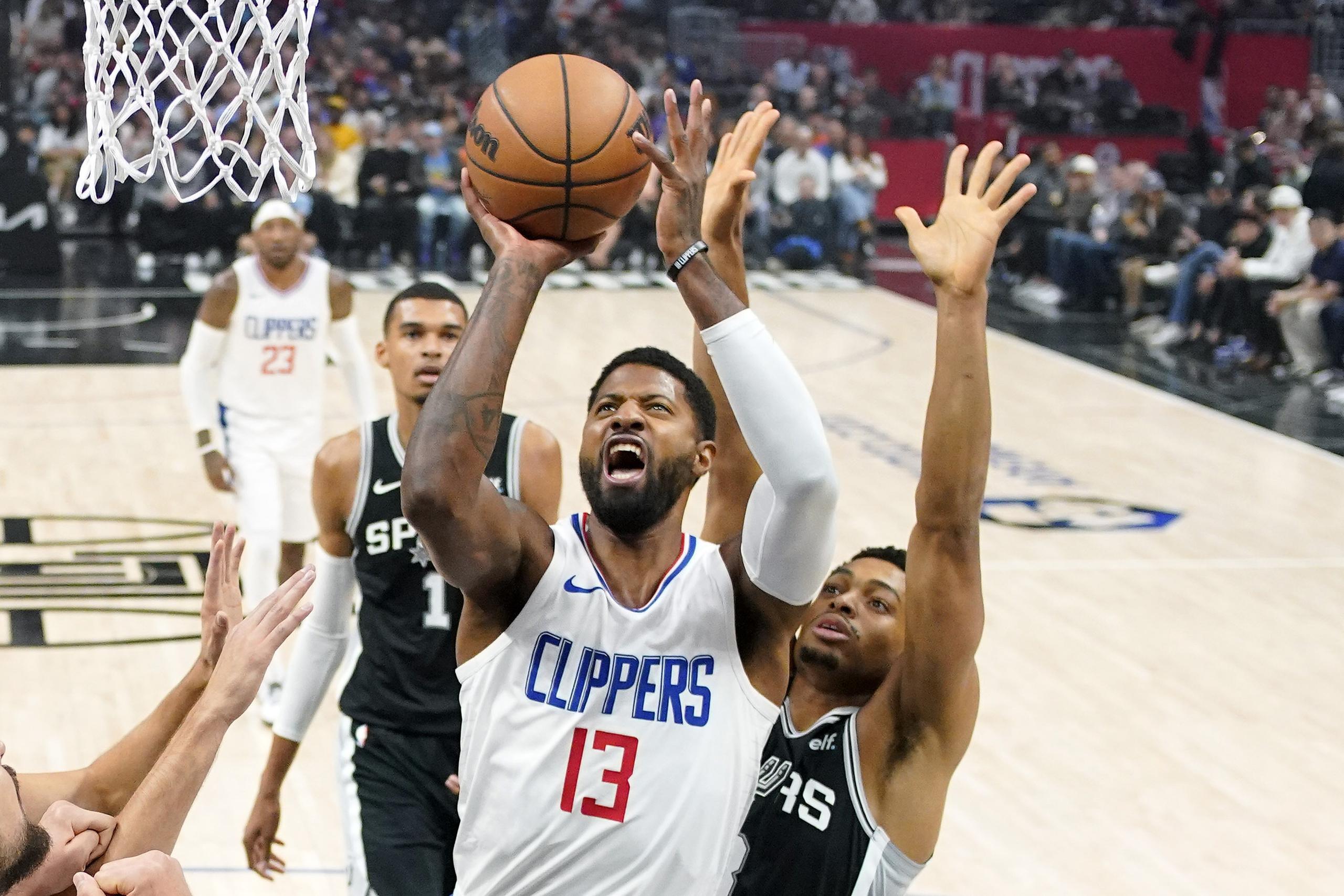 El alero de los Clippers de Los Ángeles, Paul George, lanza el balón a la canasta frente al alero de los Spurs de San Antonio Keldon Johnson en el encuentro del domingo 29 de octubre del 2023 en Los Ángeles.