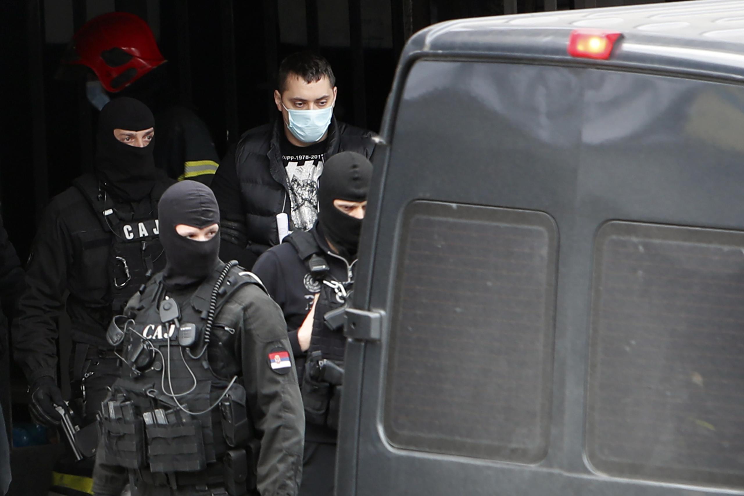 La policía serbia escolta a Veljko Belivuk (al centro), líder de la barra de Partizan, durante una redada al estadio del club de fútbol.