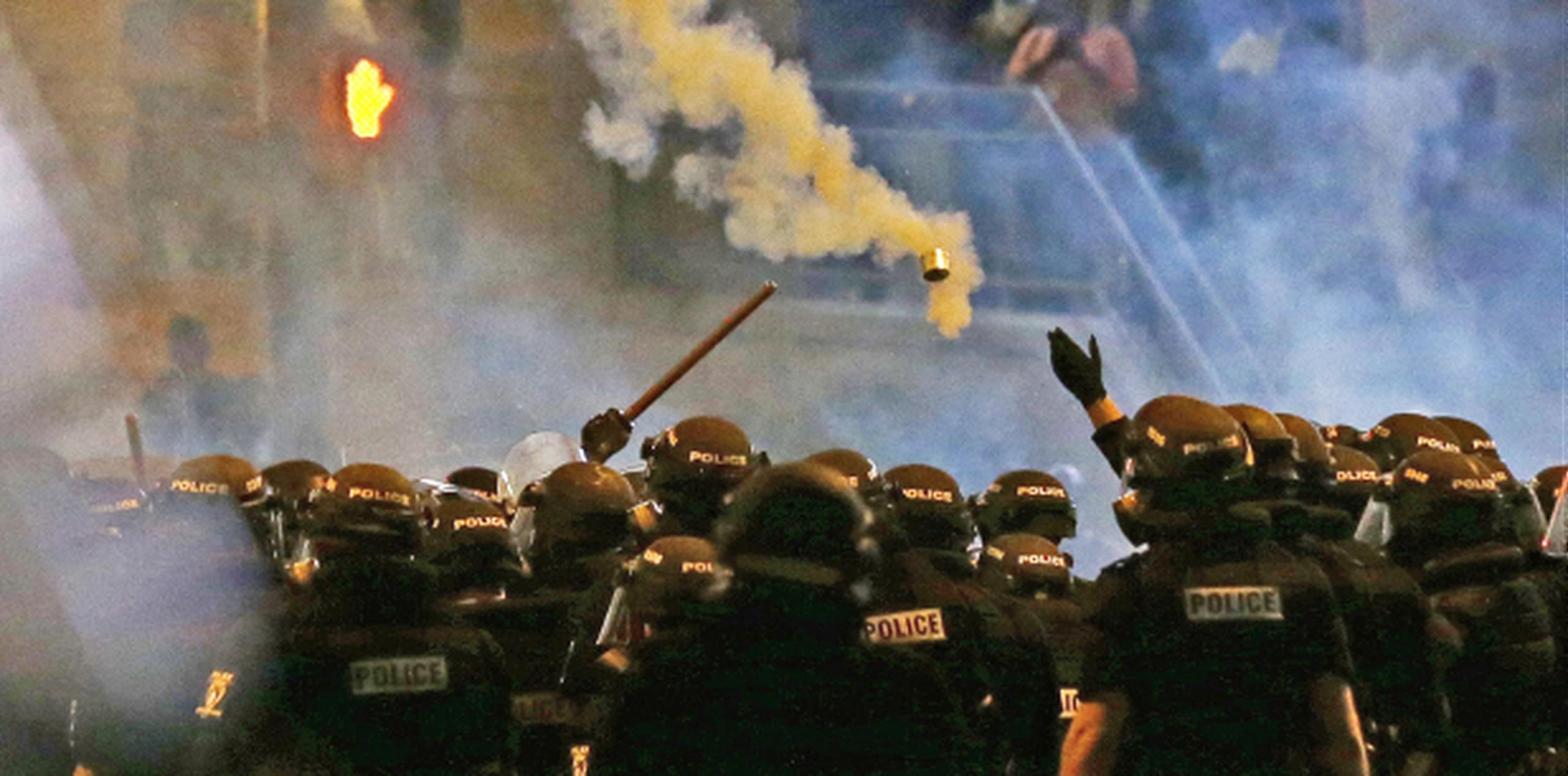 Policías tiran gas lacrimógeno a los protestantes. (AP/Gerry Broome)