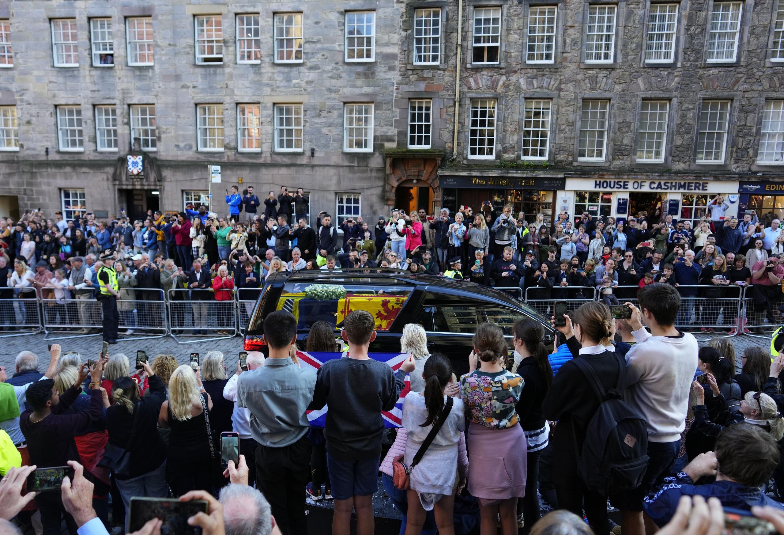 El público ve pasar el cortejo real con el coche fúnebre que trasporta el ataúd de la reina Isabel II de la catedral de San Egidio al aeropuerto de Edimburgo, Escocia.