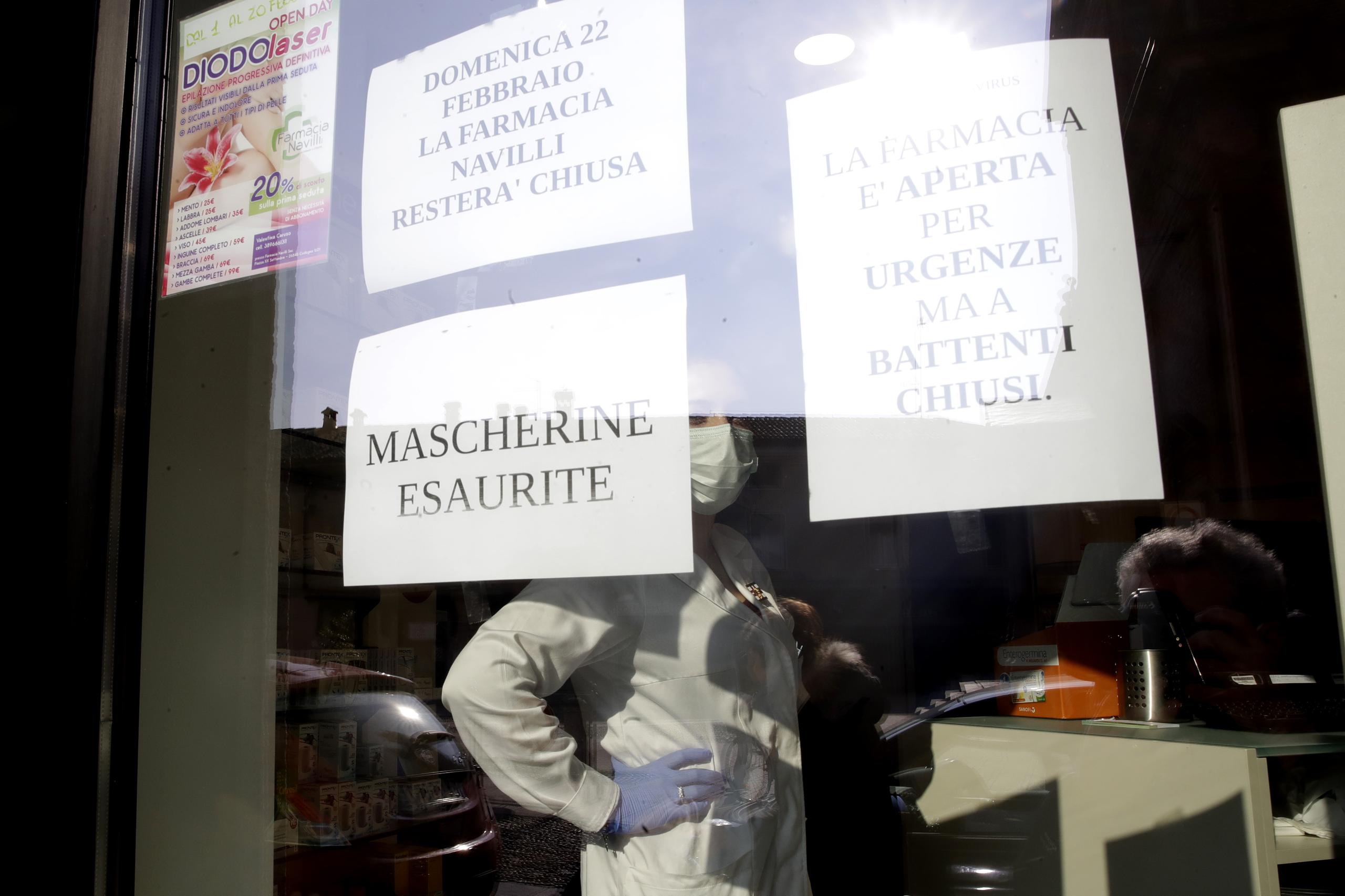 Unas notas que leen "máscaras agotadas" y "la farmacia está abierta por urgencias pero las persianas están cerradas", fueron puestas en una farmacia al norte de Italia.