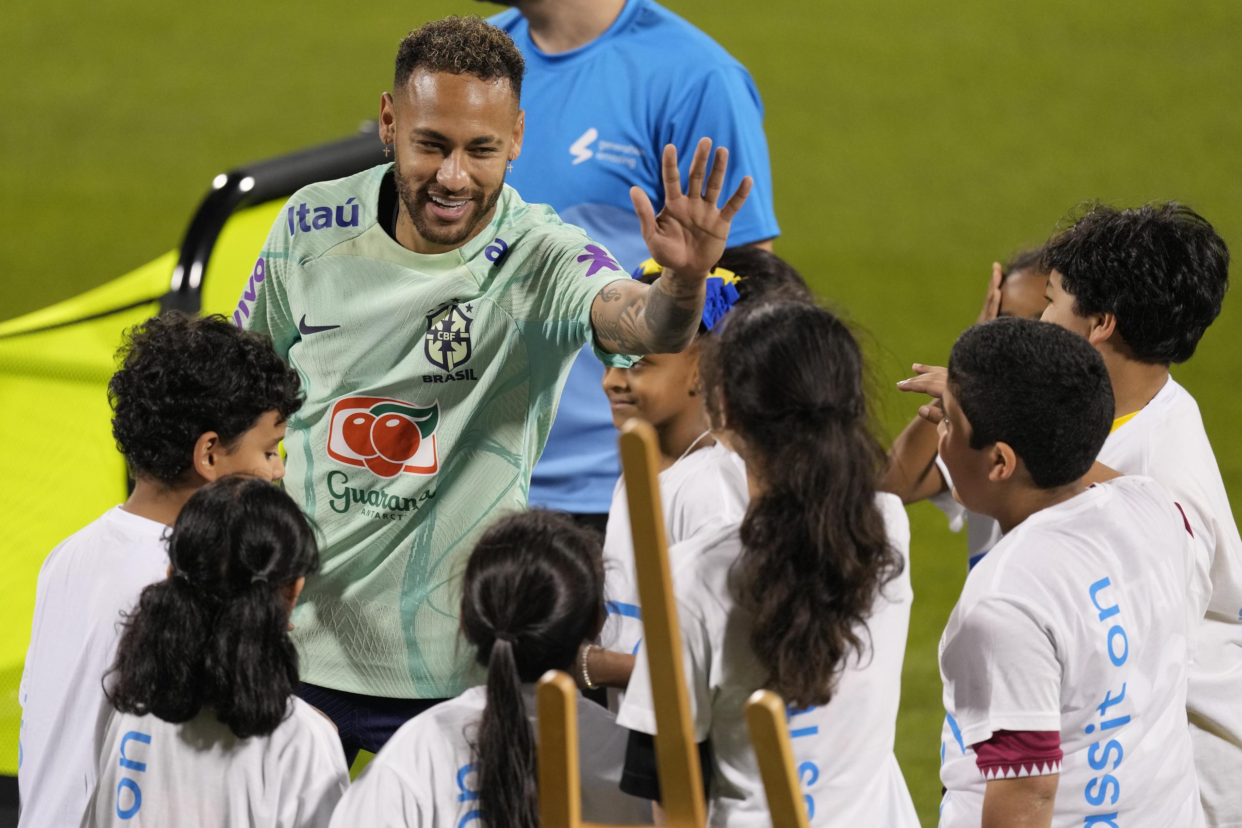 Neymar saluda a niños de un proyecto de la FIFA en un entrenamiento en el estadio Grand Hamad en Doha, Qatar.