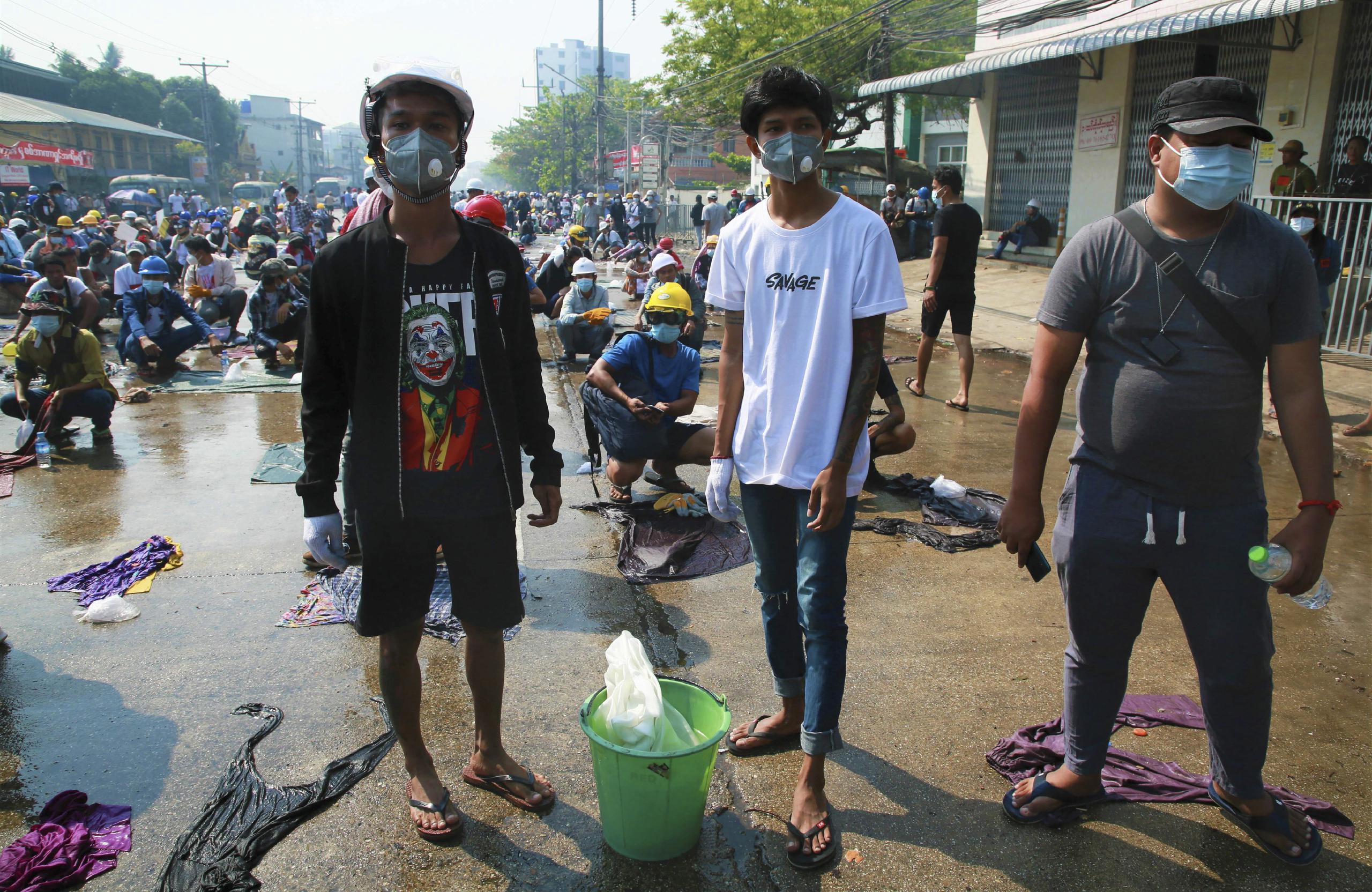 Los manifestantes se alistaban el sábado con agua y ropa mojada para extinguir las latas de gases lacrimógenos en uno de los enfrentamientos contra las fuerzas de la junta militar.