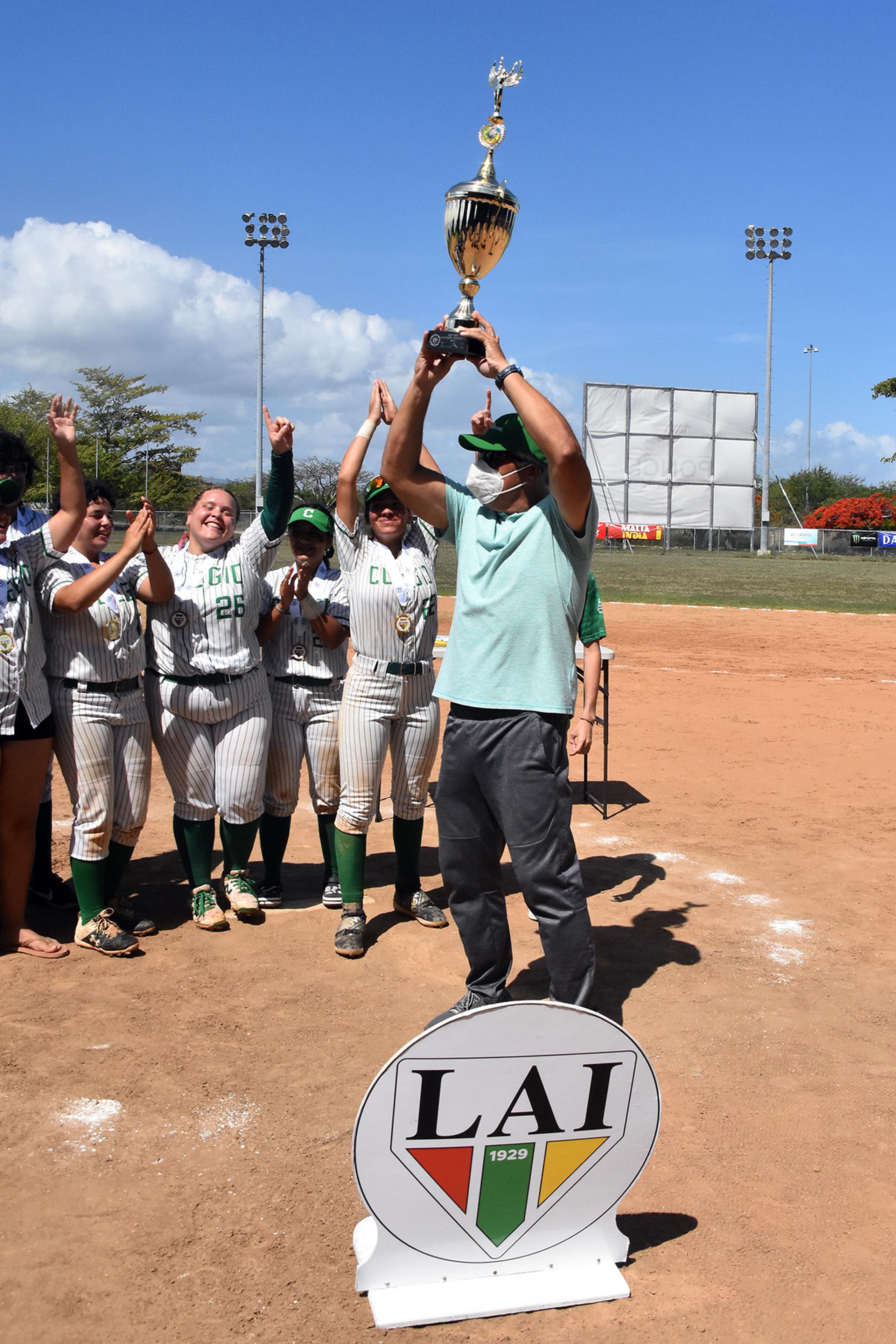 El director atlético de la UPR Mayagüez, Félix Vega, levanta la copa de campeón al cierre del torneo de sóftbol de la LAI.