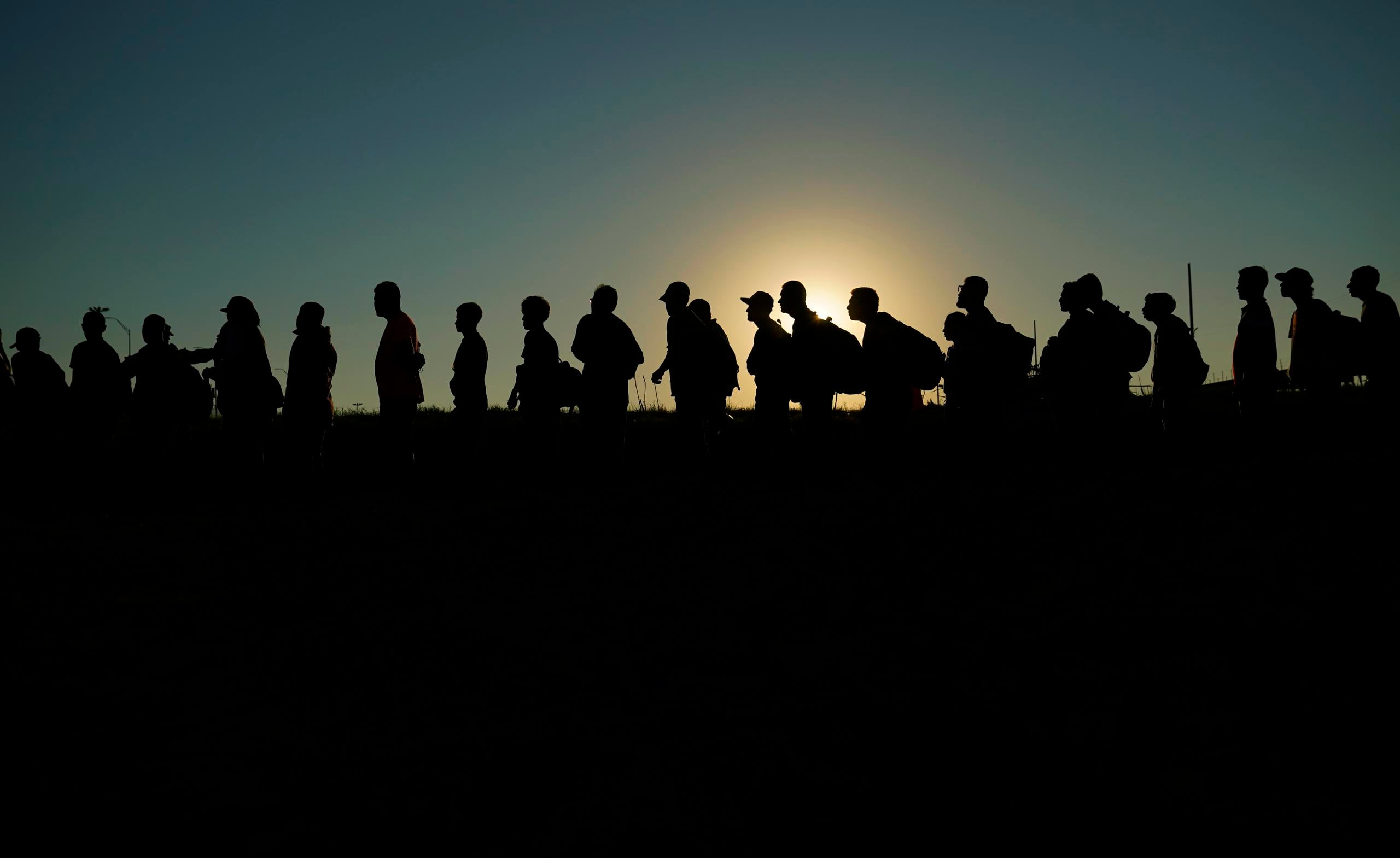Migrantes que cruzaron el río Bravo (o Grande) y entraron a Estados Unidos desde México formados para ser procesados por la Oficina de Aduanas y Protección Fronteriza, el 23 de septiembre de 2023, en Eagle Pass, Texas. (AP Foto/Eric Gay, Archivo)